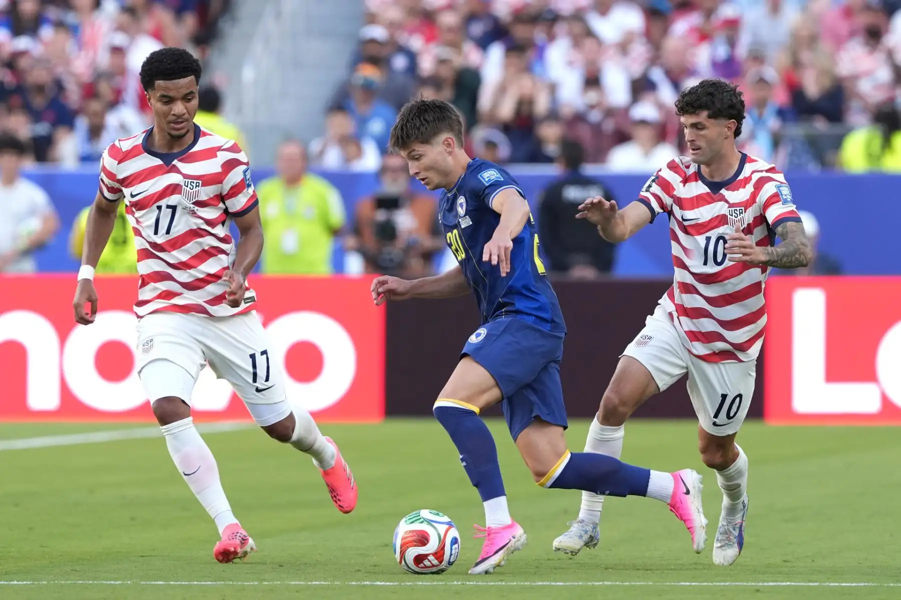 Christian Pulisic y Malik Tillman  de Estados Unidos disputan un balón con Esmir Bajraktarevic de Bosnia este miércoles, en un partido de los dieciseisavos de final del Mundial de la FIFA 2026 entre Estados Unidos y Bosnia Herzegovina en el estadio Levi
