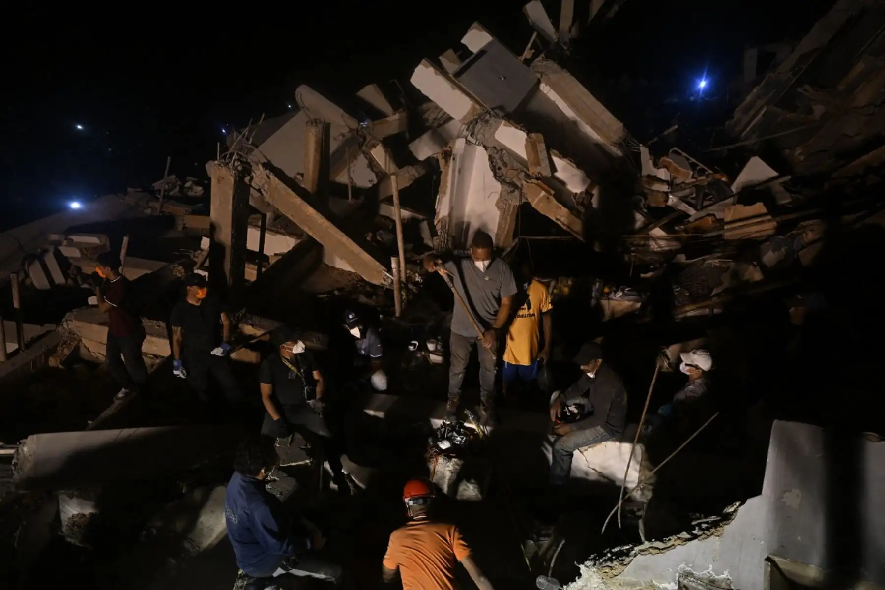 Varias personas buscan a sus familiares fallecidos entre los escombros de un edificio derrumbado en el barrio Los Corales de Caraballeda, estado de La Guaira, Venezuela. Foto: AFP