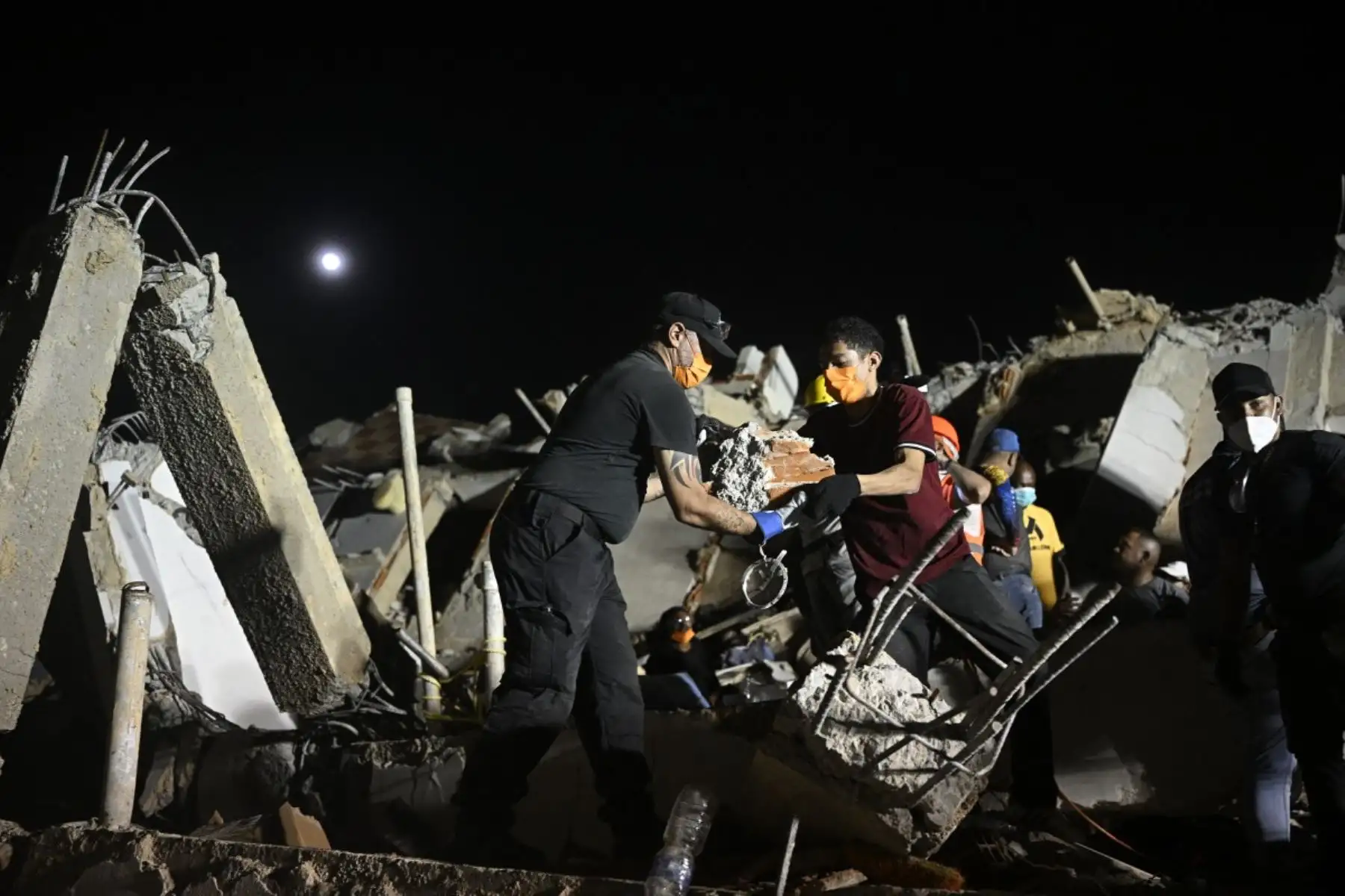 Varias personas buscan a sus familiares fallecidos entre los escombros de un edificio derrumbado en el barrio Los Corales de Caraballeda, estado de La Guaira, Venezuela. Foto: AFP
