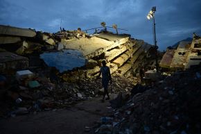 Una persona camina entre edificios derrumbados en Caraballeda, estado de La Guaira, Venezuela. Foto: AFP