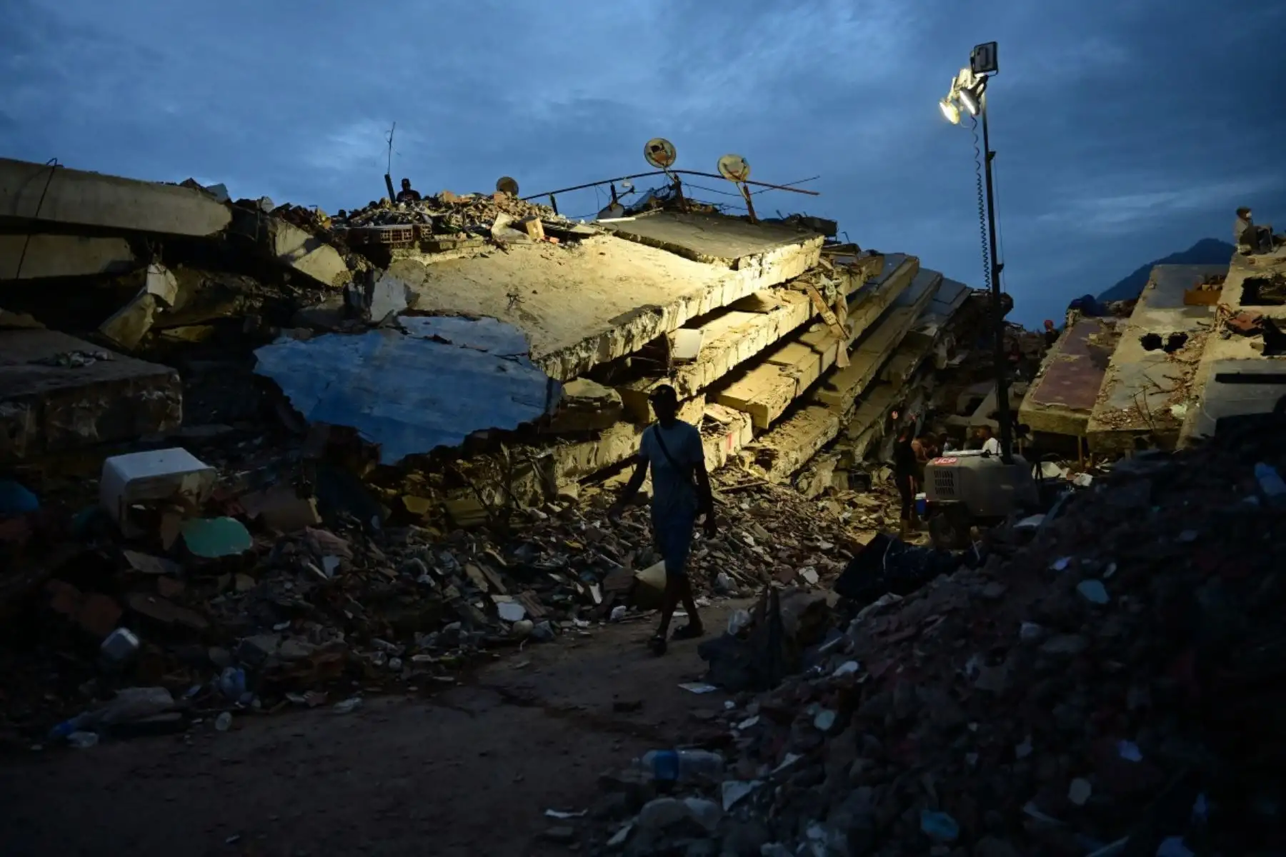 Una persona camina entre edificios derrumbados en Caraballeda, estado de La Guaira, Venezuela, el 3 de julio de 2026. El número de muertos por los devastadores terremotos gemelos en Venezuela ha aumentado a 2.645, con más de 12.600 heridos, según nuevas cifras oficiales publicadas el 3 de julio. Foto: AFP