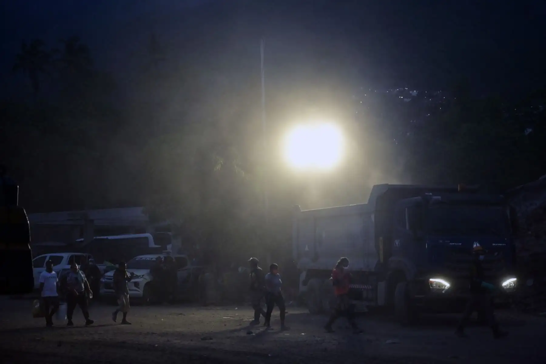 Varias personas pasan junto a un camión cargado de escombros en el lugar donde se derrumbaron los edificios en Caraballeda, estado de La Guaira, Venezuela, el 3 de julio de 2026. Foto: AFP