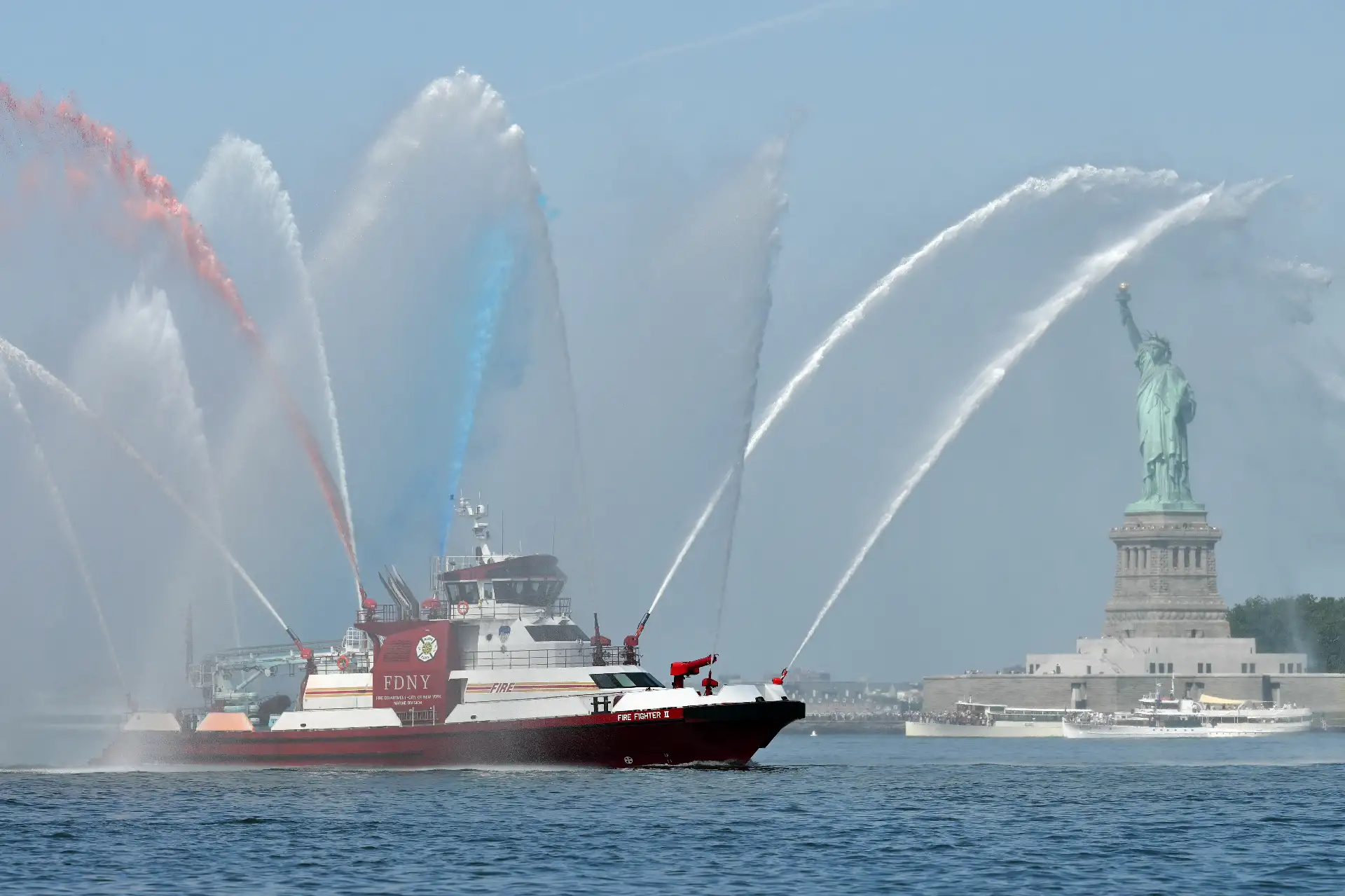 Un barco del Departamento de Bomberos de Nueva York navega frente a la Estatua de la Libertad durante el evento "Sail 4th 250" el 4 de julio de 2026. Millones de estadounidenses celebran este sábado el 250 aniversario de los Estados Unidos de América. Foto: AFP