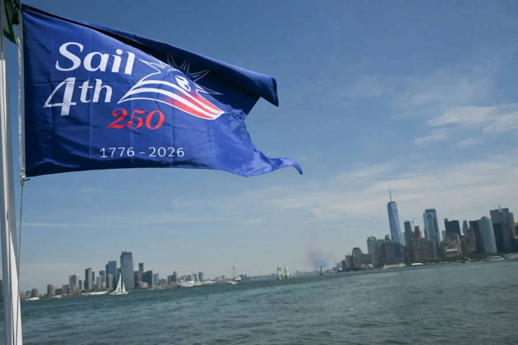 La bandera de un barco navega frente al puerto de Nueva York durante el evento «Sail 4th 250» el 4 de julio de 2026. Millones de estadounidenses celebraron el sábado el 250 aniversario del país, una conmemoración histórica que tiene lugar en un momento de profunda división política. Foto: AFP