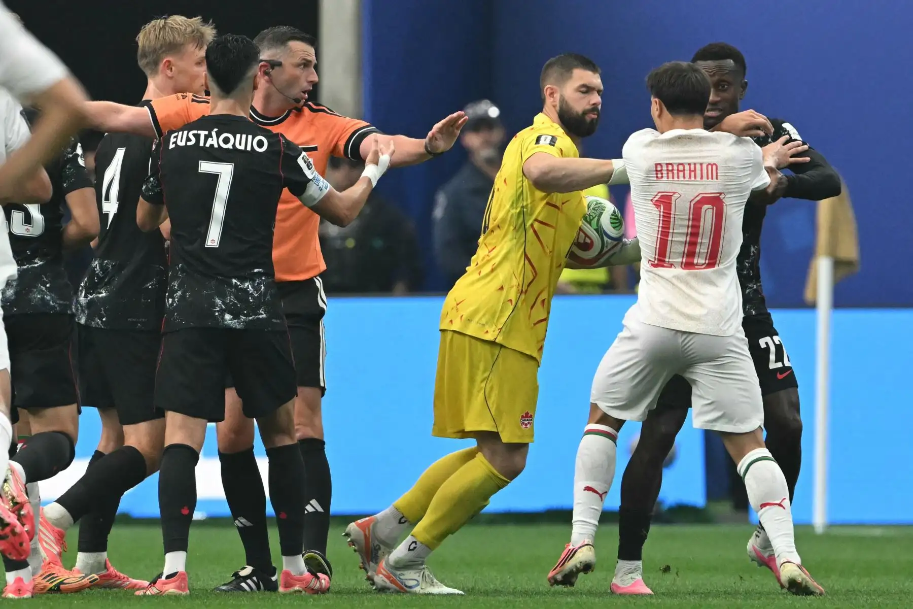 El delantero de Marruecos, Brahim Díaz, discute con el portero de Canadá, Maxime Crépeau, y el defensa Richie Laryea, junto al árbitro inglés Michael Oliver durante el partido de octavos de final de la Copa Mundial 2026 entre Canadá y Marruecos, disputado en el estadio de Houston el 4 de julio de 2026. Foto: AFP