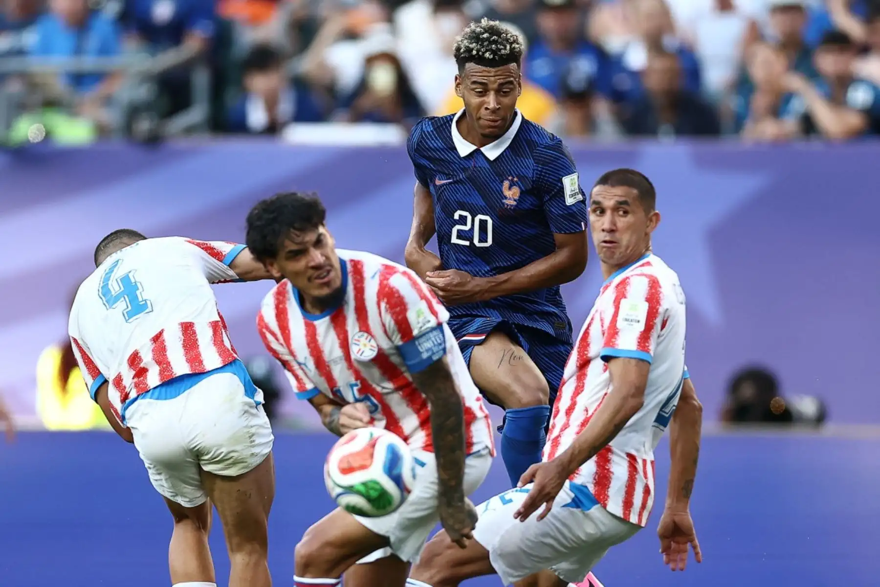 El defensa paraguayo número 4, Juan José Cáceres, el defensa paraguayo número 15, Gustavo Gómez, y el defensa paraguayo número 2, Gustavo Velázquez, luchan por el balón con el delantero francés número 20, Desire Doue, durante el partido de octavos de final del Mundial de 2026 entre Paraguay y Francia en el Estadio de Filadelfia, el 4 de julio de 2026. (Foto de CHARLY TRIBALLEAU / AFP)