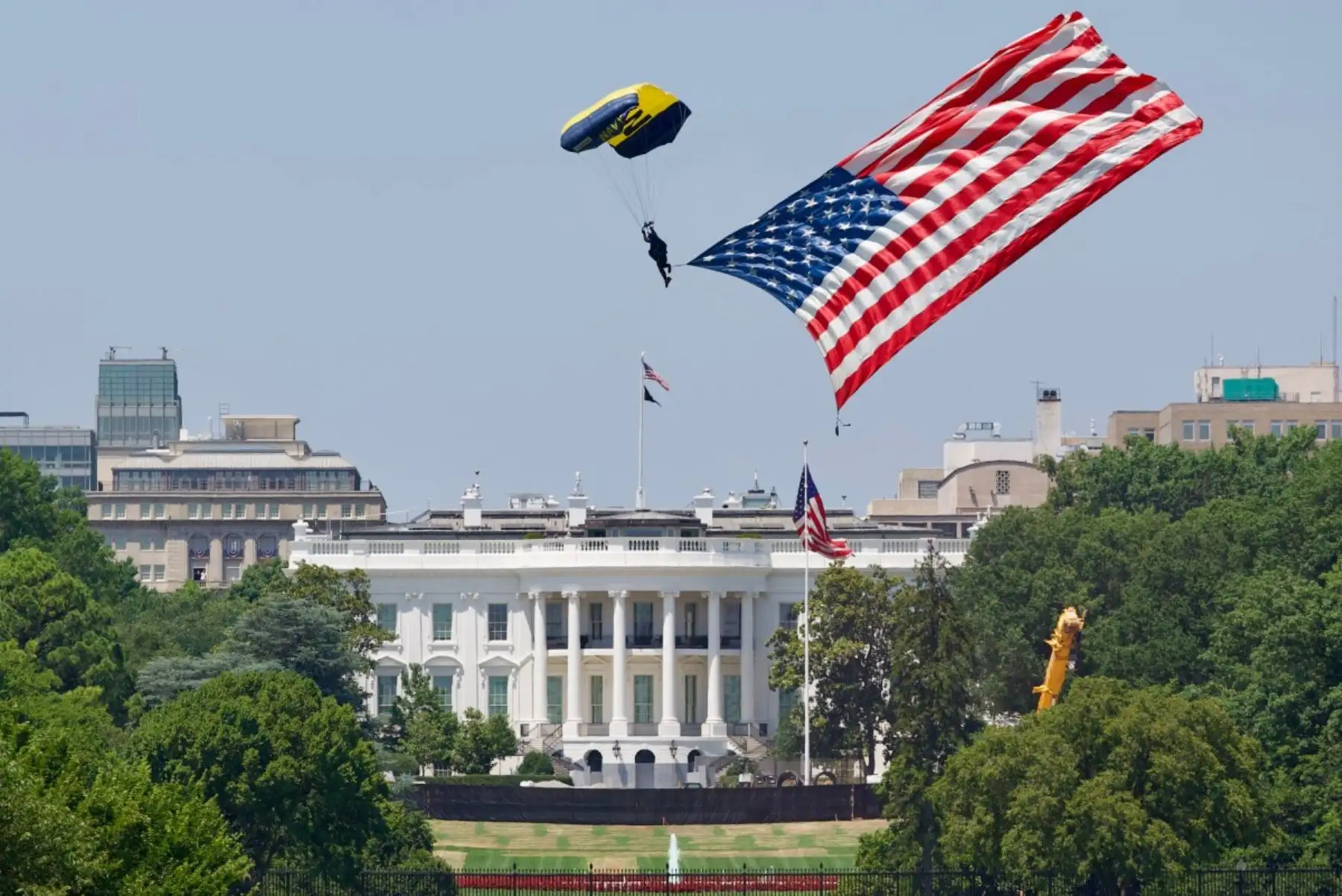 Un miembro del equipo de paracaidistas de la Marina de los EE. UU. "Leap Frogs" aterriza con una bandera estadounidense gigante en la Elipse, cerca de la Casa Blanca, durante la celebración del Día de la Independencia "Salute to America" ​​en el National Mall de Washington, D.C., el 4 de julio de 2026. La nación conmemora el 250 aniversario de la Declaración de Independencia de los Estados Unidos. Foto: AFP