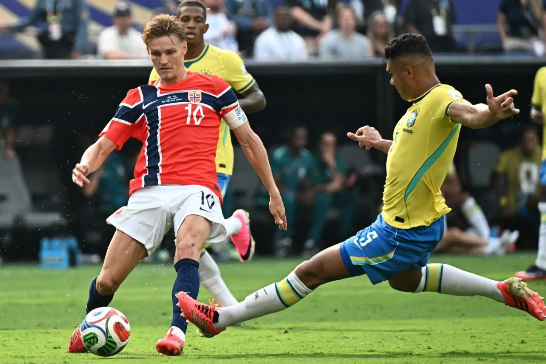 El centrocampista noruego Martin Odegaard (número 10) y el centrocampista brasileño Casemiro (número 5) luchan por el balón durante el partido de octavos de final del Mundial de 2026 entre Brasil y Noruega, disputado en el estadio New York/New Jersey de East Rutherford el 5 de julio de 2026. (Foto de Jewel SAMAD / AFP)