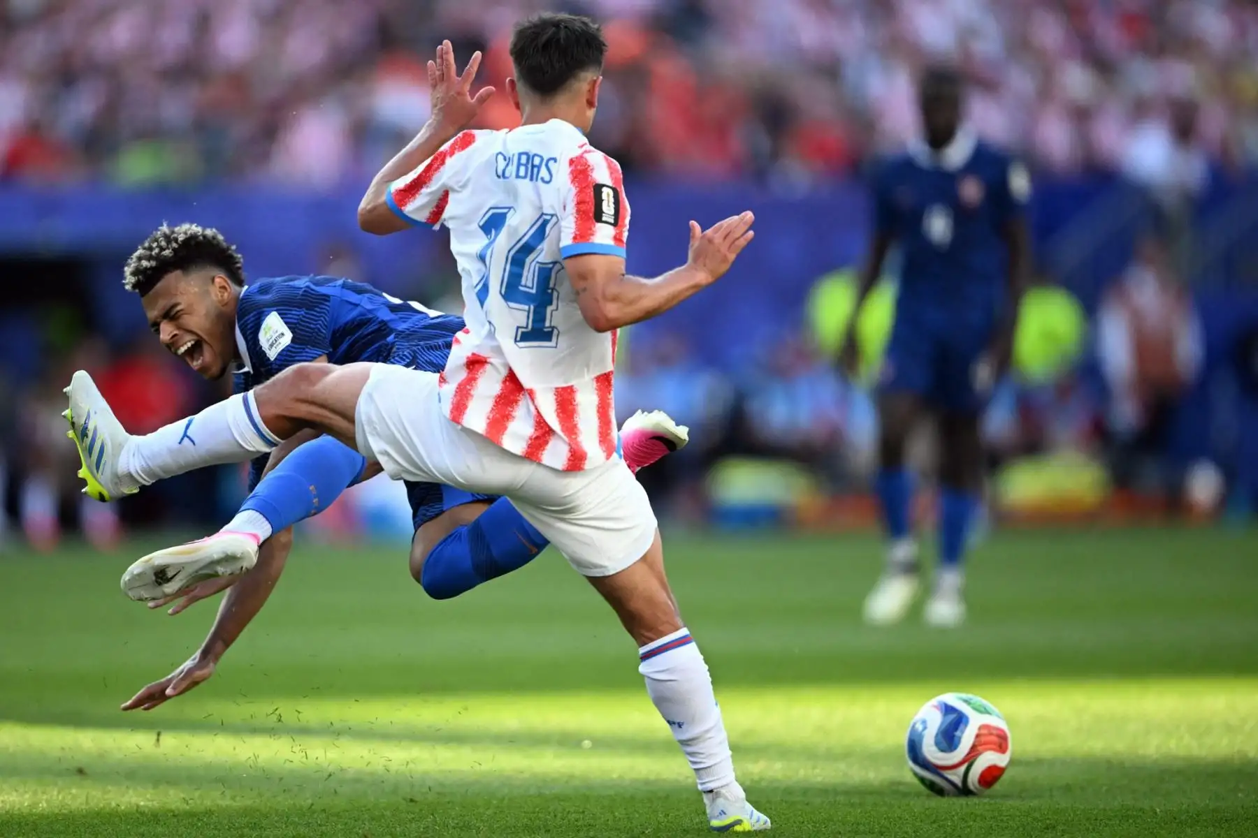 El delantero francés n.º 20, Désiré Doué, cae al pasar junto al centrocampista paraguayo n.º 14, Andrés Cubas, durante el partido de octavos de final de la Copa Mundial de 2026 entre Paraguay y Francia, disputado en el Philadelphia Stadium de Filadelfia el 4 de julio de 2026. Foto: AFP