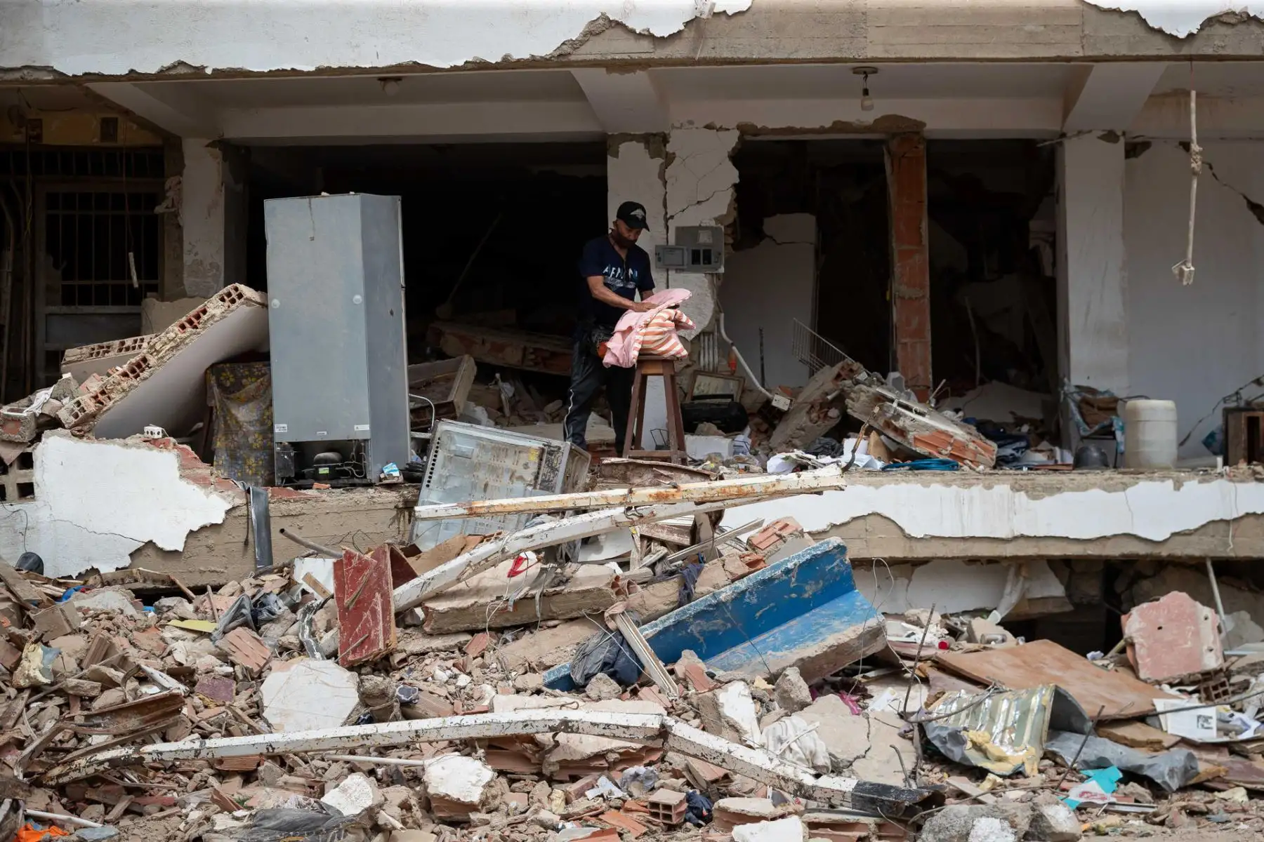 Una persona busca pertenencias en medio de los escombros de un edificio este domingo, en La Guaira (Venezuela). A las calles de La Guaira, la zona devastada por el doble terremoto de Venezuela, han llegado en las últimas horas decenas de máquinas amarillas para retirar escombros y ayudar a acelerar las labores de recuperación de cadáveres. EFE/ Ronald Peña