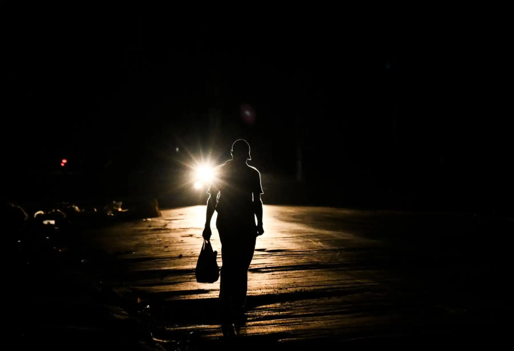 Un hombre camina por una calle durante un apagón nacional en La Habana. Cuba sufrió su segundo apagón nacional en cinco días, ya que la doble crisis energética y económica, agravada por un bloqueo de combustible estadounidense de seis meses, provocó el colapso de la red eléctrica. Foto: AFP