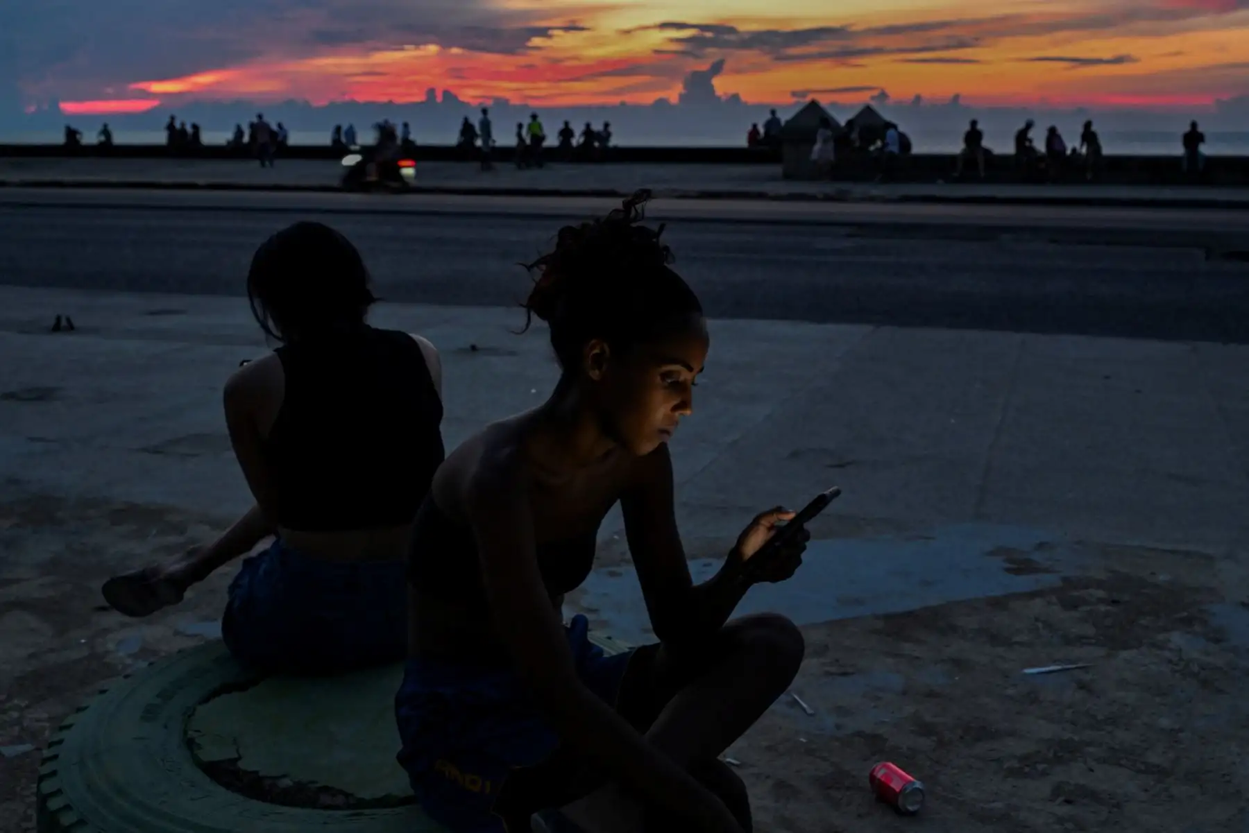 Una joven mira su teléfono móvil durante un apagón nacional en La Habana. Cuba sufrió su segundo apagón nacional en cinco días, ya que la doble crisis energética y económica, agravada por un bloqueo de combustible estadounidense de seis meses, provocó el colapso de la red eléctrica. Foto: AFP