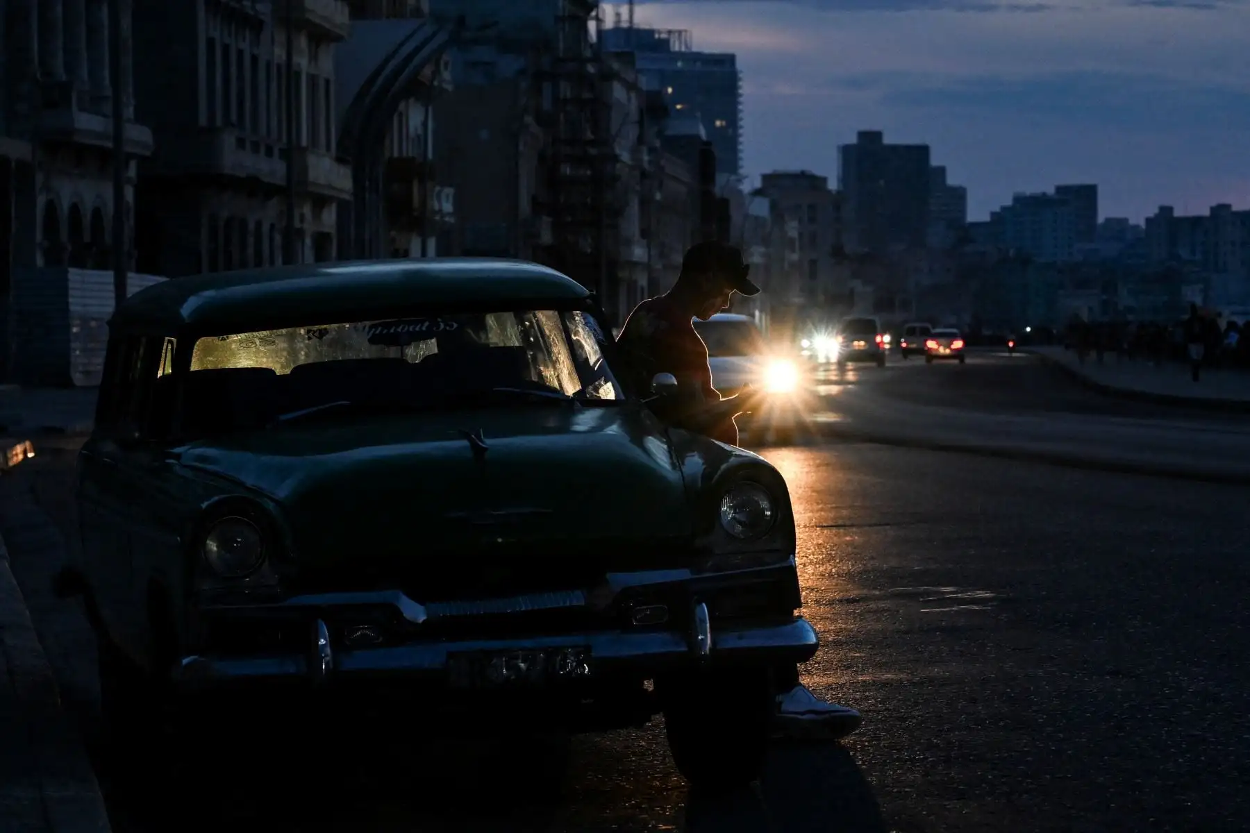 Un hombre mira su teléfono móvil durante un apagón nacional en La Habana. Cuba sufrió su segundo apagón nacional en cinco días, ya que la doble crisis energética y económica, agravada por un bloqueo de combustible estadounidense de seis meses, provocó el colapso de la red eléctrica. Foto: AFP