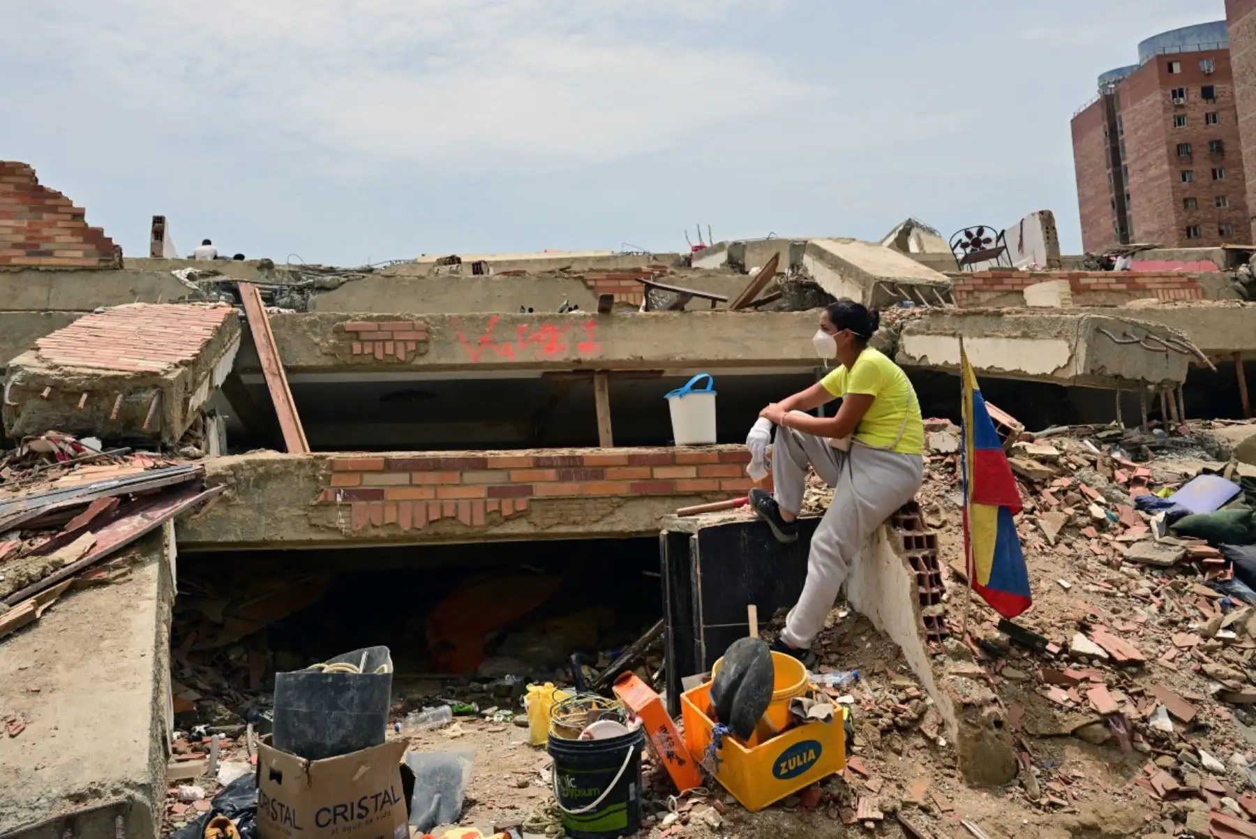 Una mujer que busca los cuerpos de sus familiares descansa entre los escombros de un edificio derrumbado en Caraballeda, estado de La Guaira, Venezuela, el 12 de julio de 2026, tras los dos terremotos que azotaron la región.
La cifra de fallecidos por los dos terremotos que sacudieron Venezuela el 24 de junio ha superado los 4.300, según informó el 11 de julio el presidente de la Asamblea Nacional, Jorge Rodríguez. Foto: AFP