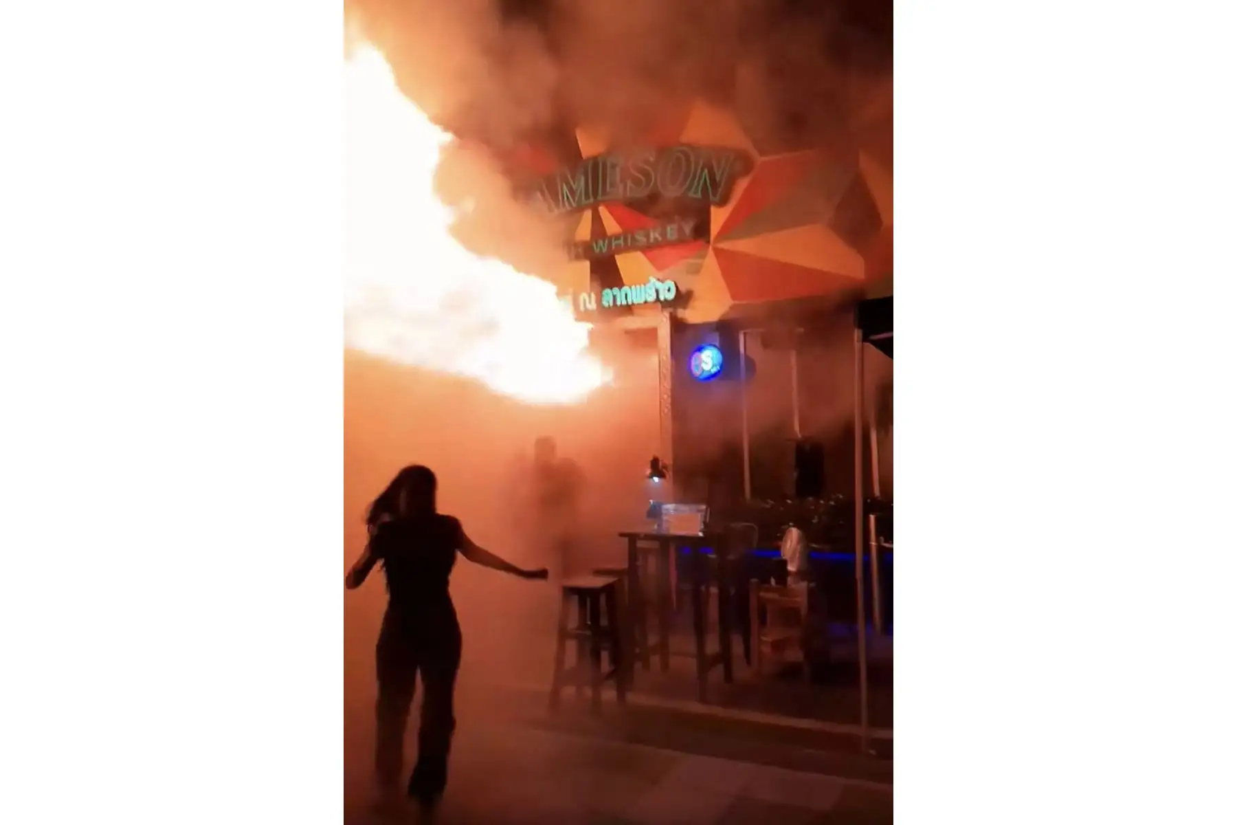 Esta captura de pantalla, tomada de un video publicado por Kan Kutirat el 12 de julio de 2026, muestra a personas huyendo de un incendio en el bar Rong Beer Na Lat Phrao en Bangkok. Foto: AFP