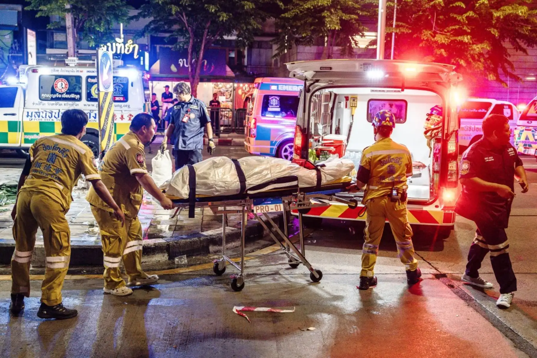 Los servicios de emergencia se preparan para trasladar el cuerpo de una víctima a una ambulancia tras un incendio en el bar Rong Beer Na Lat Phrao de Bangkok el 13 de julio de 2026. Foto: AFP