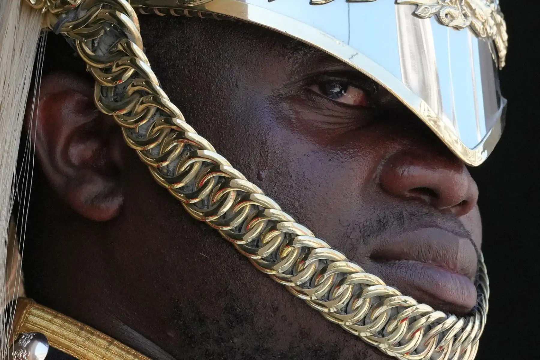 Una gota de sudor resbala por el rostro de un centinela de la Guardia Real, una unidad de la Caballería de la Casa Real, que lleva puesto su casco Albert, mientras está sentado a caballo frente a Horse Guards en Londres. Foto: AFP