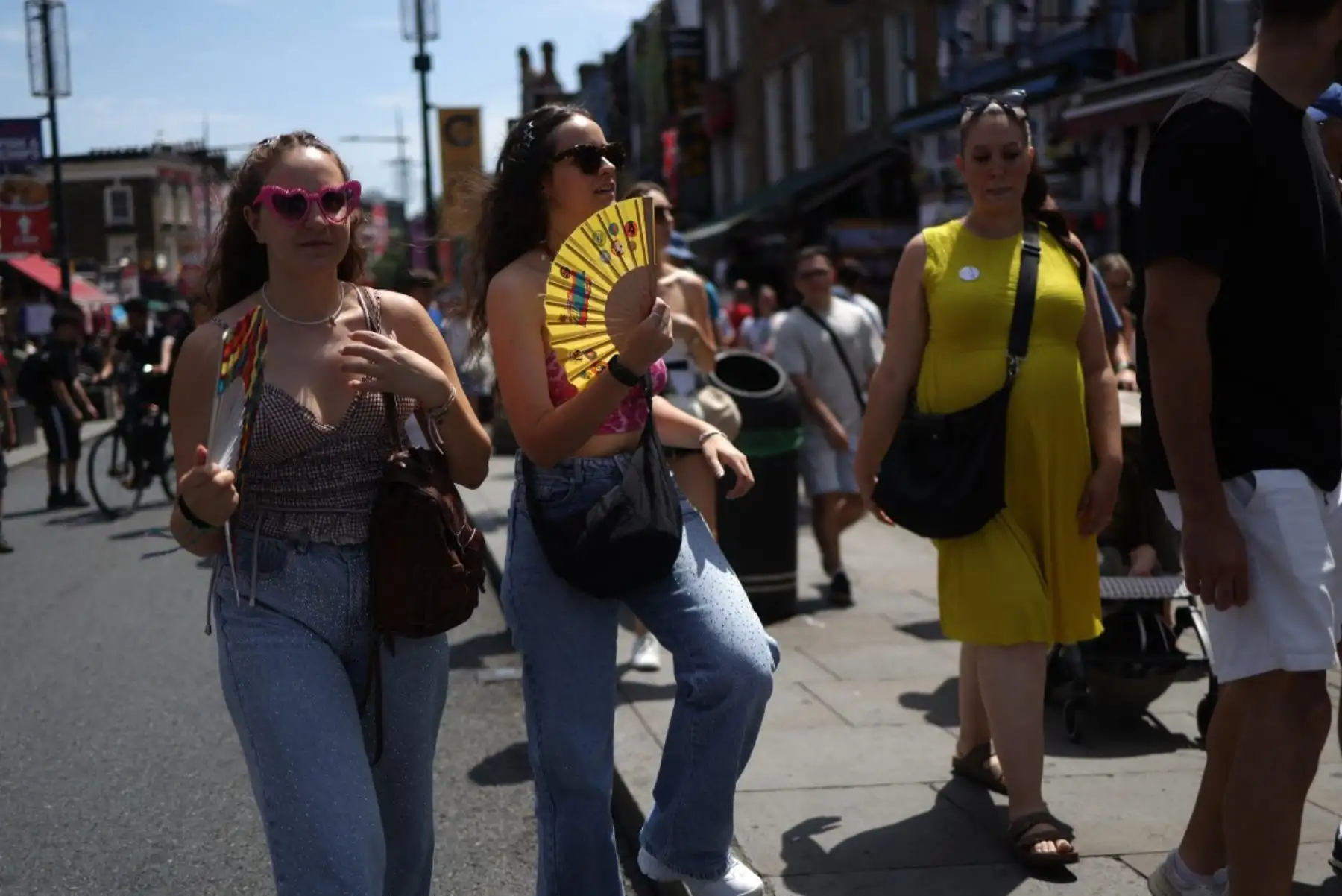 Compradores usan ventiladores mientras visitan Camden, en el centro de Londres. Foto: AFP