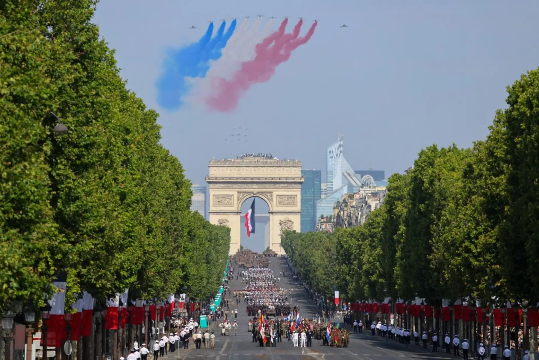 El equipo de vuelo acrobático de élite de la Fuerza Aérea francesa, la «Patrouille de France» (PAF), despliega estelas con los colores nacionales de Francia durante un vuelo de exhibición en el desfile militar anual del Día de la Bastilla en la avenida de los Campos Elíseos, con el Arco del Triunfo de fondo, en París. Foto: AFP