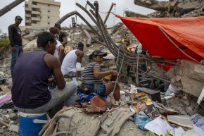Damnificados instalan campamentos frente a edificios destruidos por los terremotos del 24 de junio en Venezuela. Foto: EFE