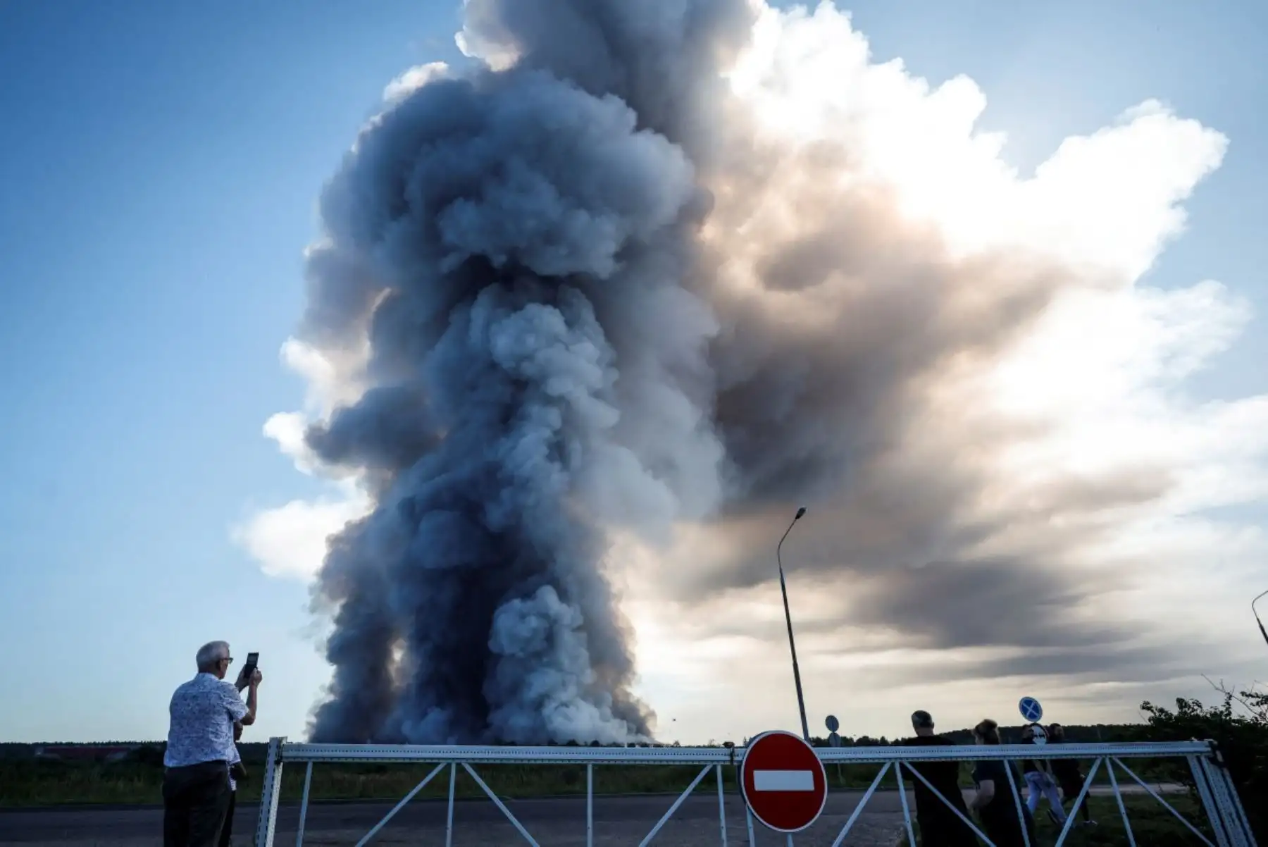 Un residente local toma una fotografía del humo de un incendio en los complejos logísticos de la empresa rusa de comercio electrónico Wildberries, en la localidad de Elektrostal (a las afueras de Moscú), el 18 de julio de 2026.
Un ataque con drones ucranianos contra dos centros logísticos en Rusia dejó ocho muertos y 24 heridos, según informaron las autoridades el 18 de julio de 2026, jornada en la que la región de Moscú reportó una nueva oleada de ataques con drones. La empresa rusa de comercio electrónico Wildberries comunicó que sus complejos logísticos en Kotovsk y Elektrostal —situados en las regiones de Tambov y Moscú, respectivamente— fueron objeto de ataques. Una persona murió y 37 resultaron heridas en el almacén de Elektrostal, según declaró el gobernador de la región, Andréi Vorobiov.
Foto: AFP