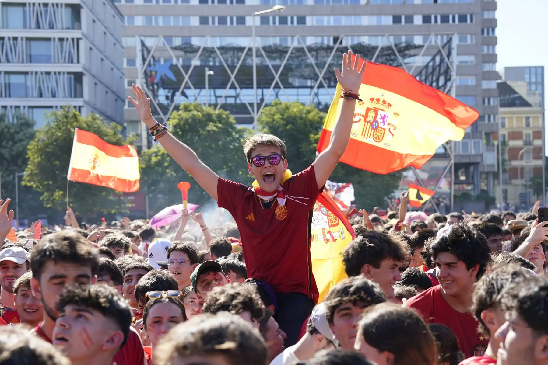 Hinchas de la selección de España animan a su equipo en la zona de aficionados de la plaza de Colón, en Madrid, antes de la final del Mundial de 2026 entre España y Argentina, el 19 de julio de 2026. Foto: AFP