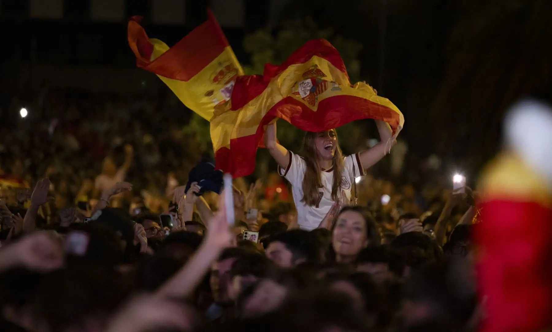 Aficionados de la selección española junto al estadio de Anoeta de San Sebastián, donde se ha instalado una pantalla gigante para seguir el encuentro de la final del Mundial 2026 que disputan este domingo España y Argentina en el MetLife de Nueva Jersey. Foto: EFE