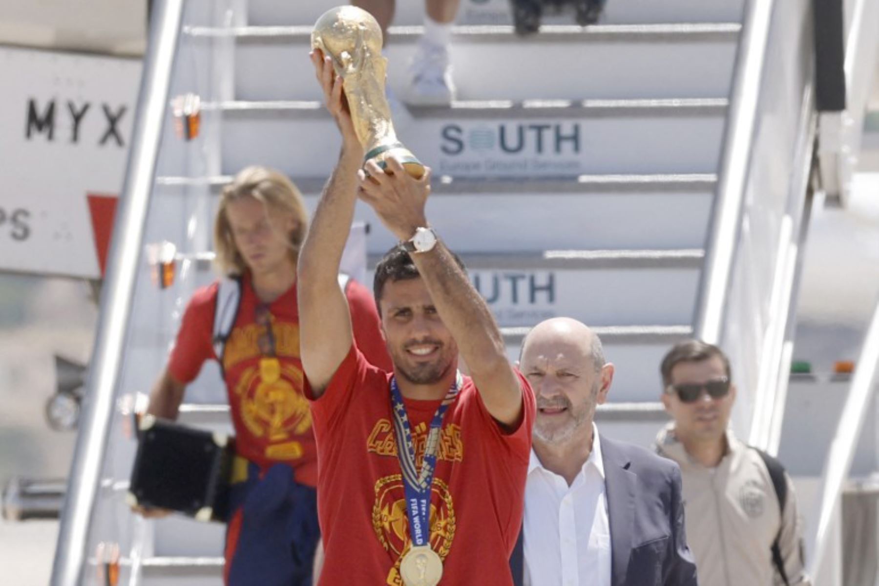 El seleccionador de la selección española de fútbol, ​​Luis de la Fuente, el centrocampista Rodri  y el presidente de la Federación Española de Fútbol, ​​Rafael Louzán, posan con el trofeo a su llegada desde Estados Unidos tras ganar la Copa del Mundo de 2026. Foto: AFP