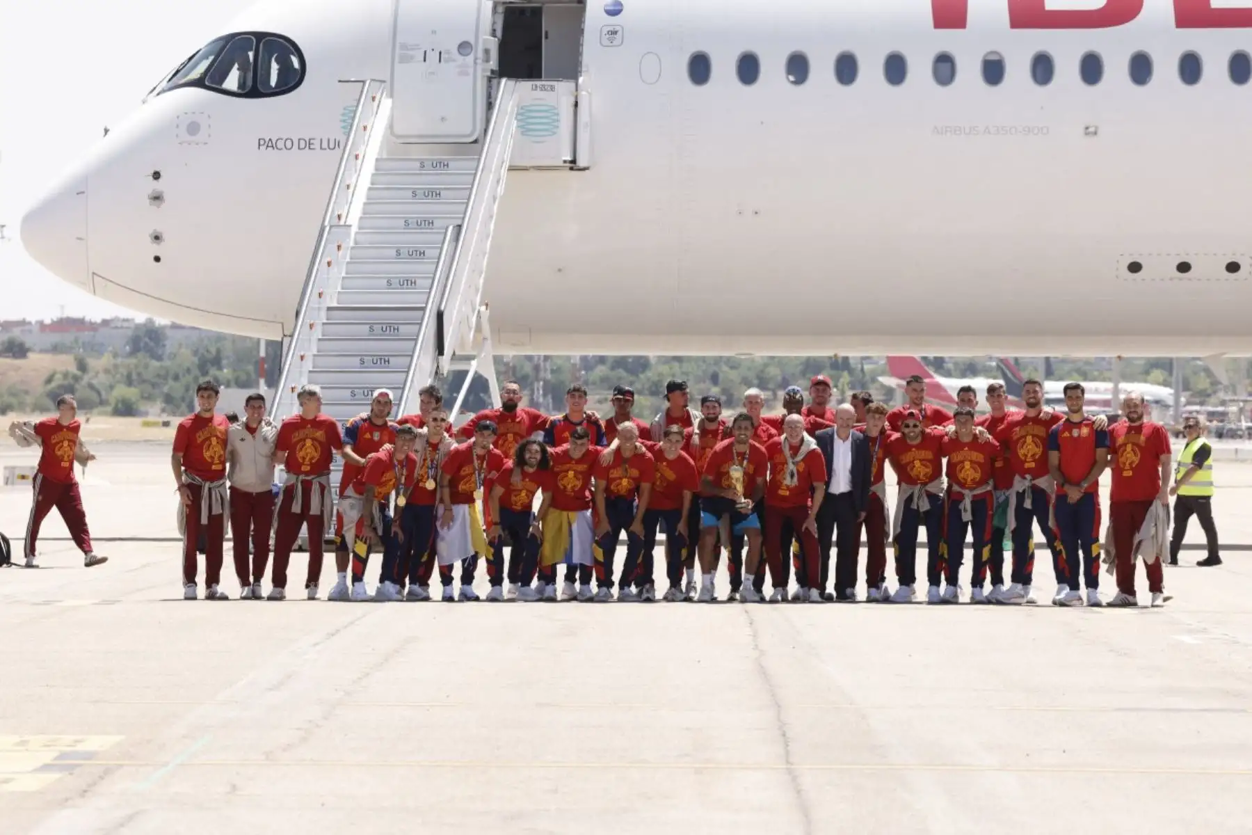 La selección española posa con su trofeo en la pista tras su llegada desde Estados Unidos después de ganar el Mundial de 2026, en Madrid-Barajas. Foto: AFP