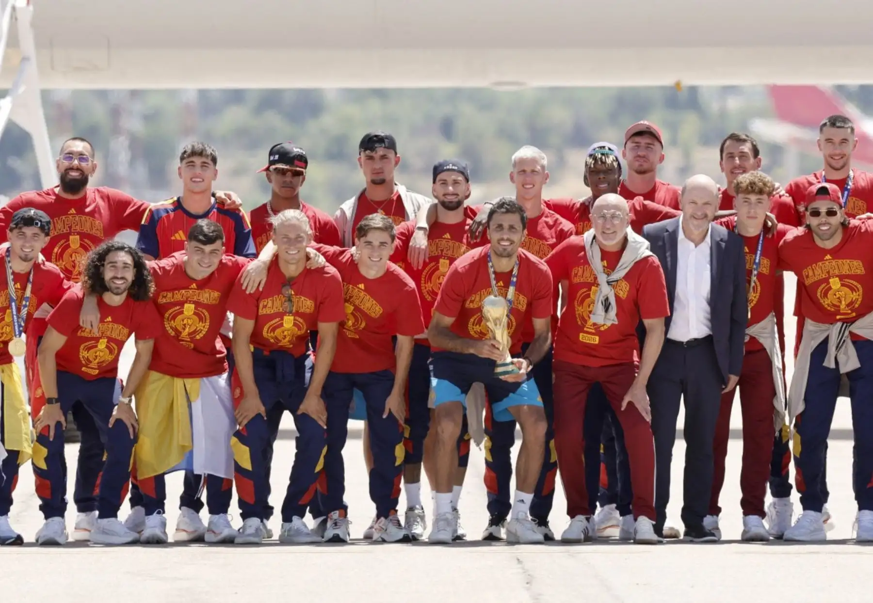 La selección española posa con su trofeo en la pista tras su llegada desde Estados Unidos después de ganar el Mundial de 2026, en Madrid-Barajas. Foto: AFP