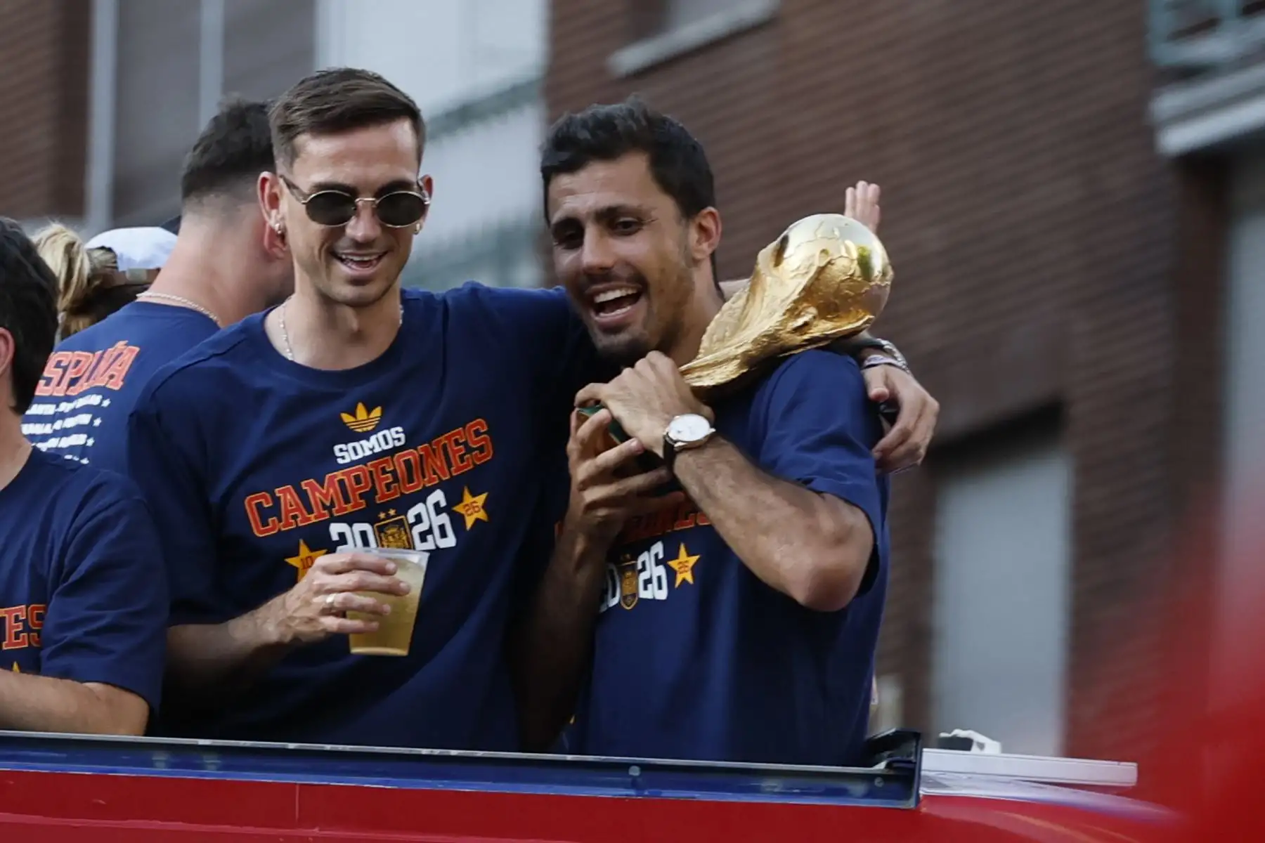 Los jugadores de la selección española Rodri  y Fabián Ruiz  a su paso por la calle Princesa de Madrid durante la celebración tras proclamarse ayer campeones del mundo al derrotar en la final a Argentina. Foto: EFE