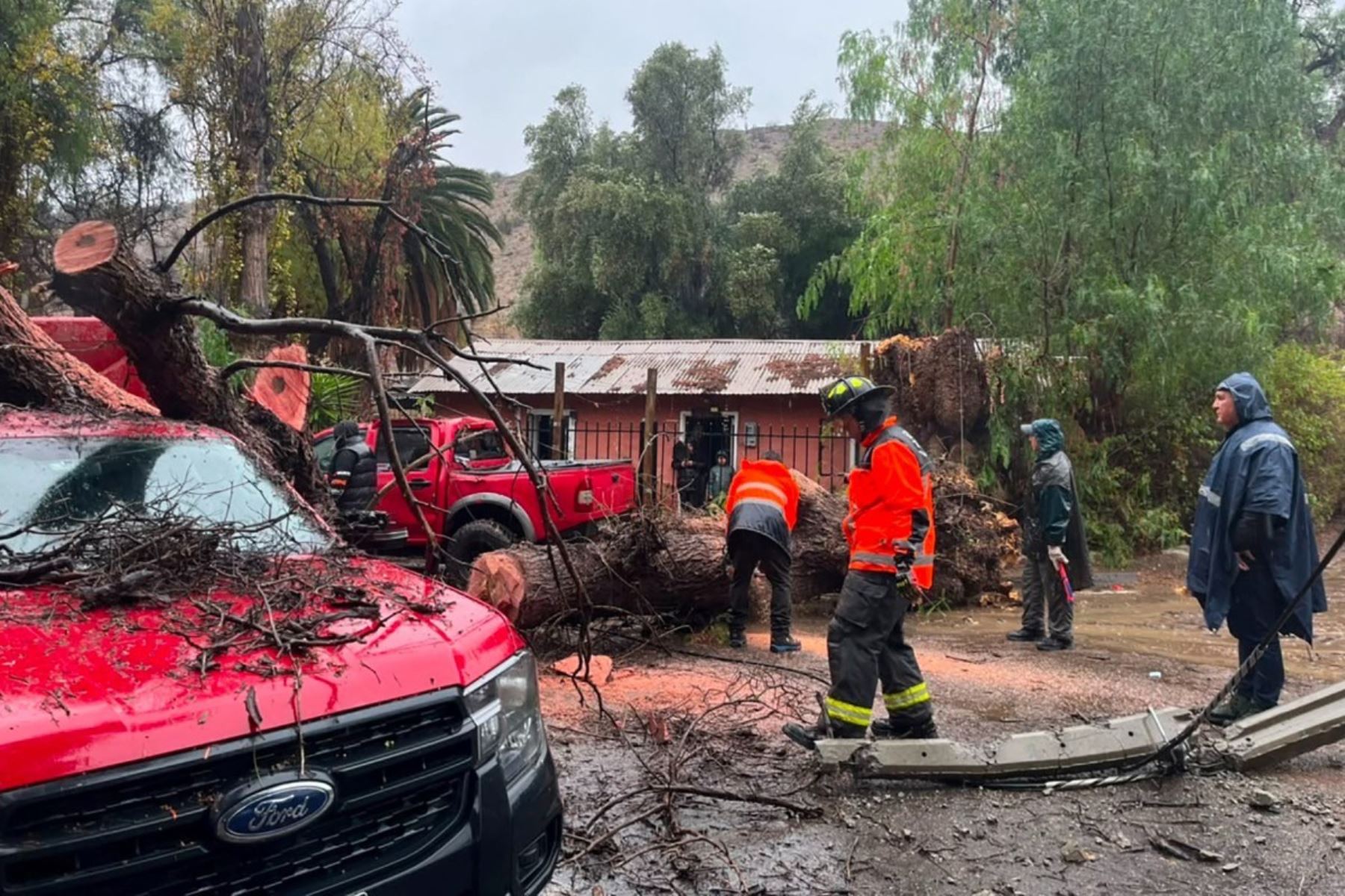 Esta fotografía, difundida por la Red Comunal de Chile, muestra a bomberos realizando una operación de rescate en La Serena, Chile, tras las fuertes lluvias. Las intensas precipitaciones en Chile causaron la muerte de cinco personas y destruyeron o dañaron gravemente más de 1000 viviendas, lo que llevó al gobierno a declarar el estado de emergencia el 20 de julio de 2026. Foto: AFP