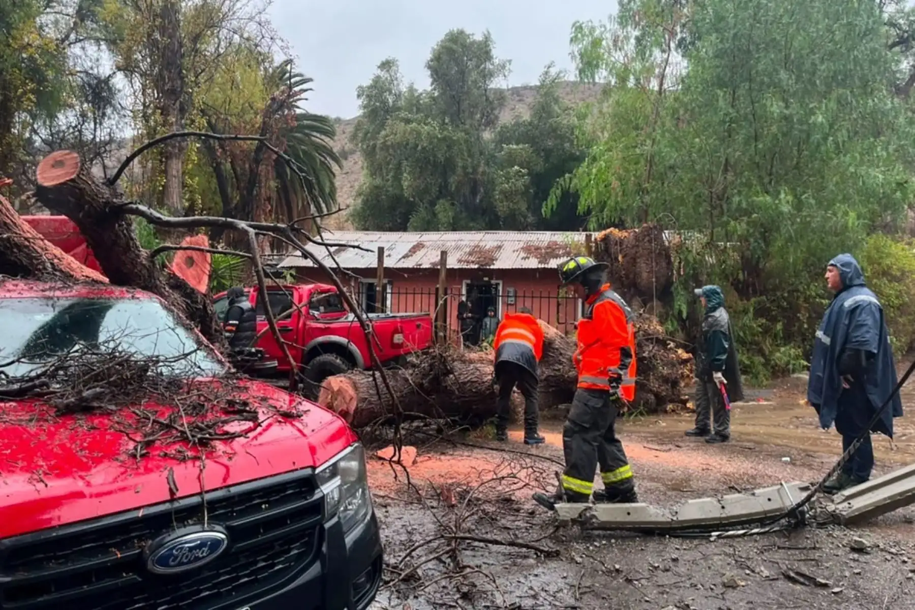 Esta fotografía, difundida por la Red Comunal de Chile, muestra a bomberos realizando una operación de rescate en La Serena, Chile, tras las fuertes lluvias. Las intensas precipitaciones en Chile causaron la muerte de cinco personas y destruyeron o dañaron gravemente más de 1000 viviendas, lo que llevó al gobierno a declarar el estado de emergencia el 20 de julio de 2026. Foto: AFP