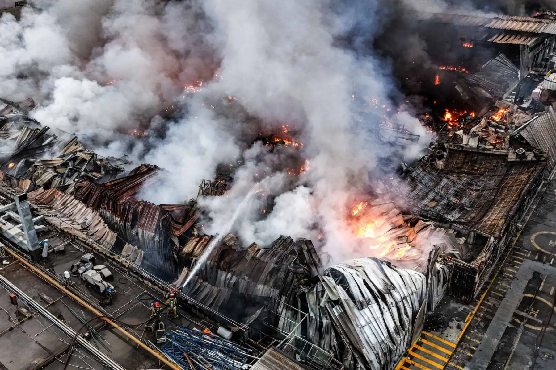 Las llamas comprometen gran parte de las instalaciones de la planta de Yobel, mientras los bomberos ejecutan acciones para evitar la propagación del fuego a inmuebles vecinos. Foto: ANDINA/ Juan Carlos Guzmán