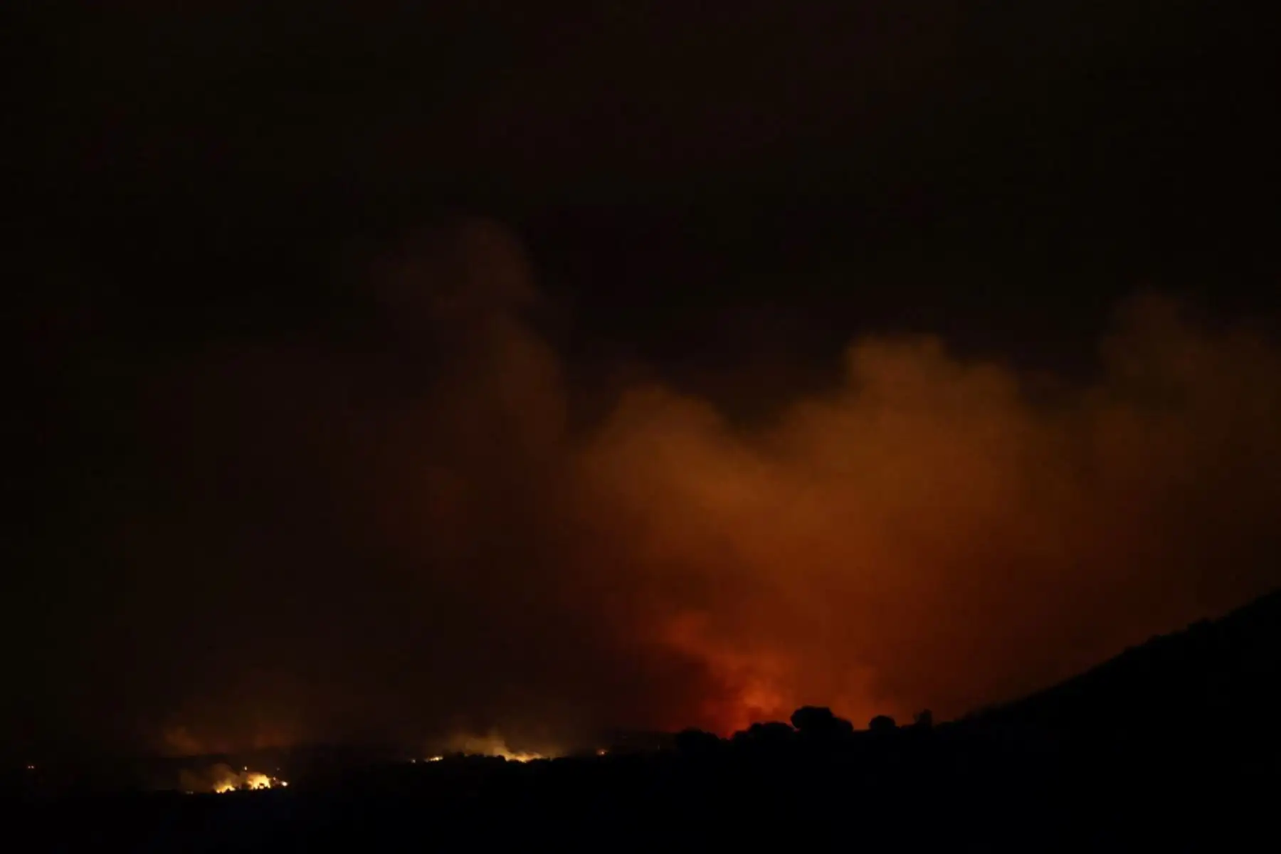 Una fotografía tomada el 24 de julio de 2026 en Puerto de la Cruz Verde, cerca de Ávila, a 80 km al oeste de Madrid, muestra una vista nocturna de un incendio forestal que azota al oeste de la capital española.
Los peores incendios forestales en la historia de la Comunidad de Madrid se extienden al oeste de la capital, obligando a las autoridades a evacuar o a ordenar a unas 40.000 personas que permanezcan en sus casas. Foto: AFP