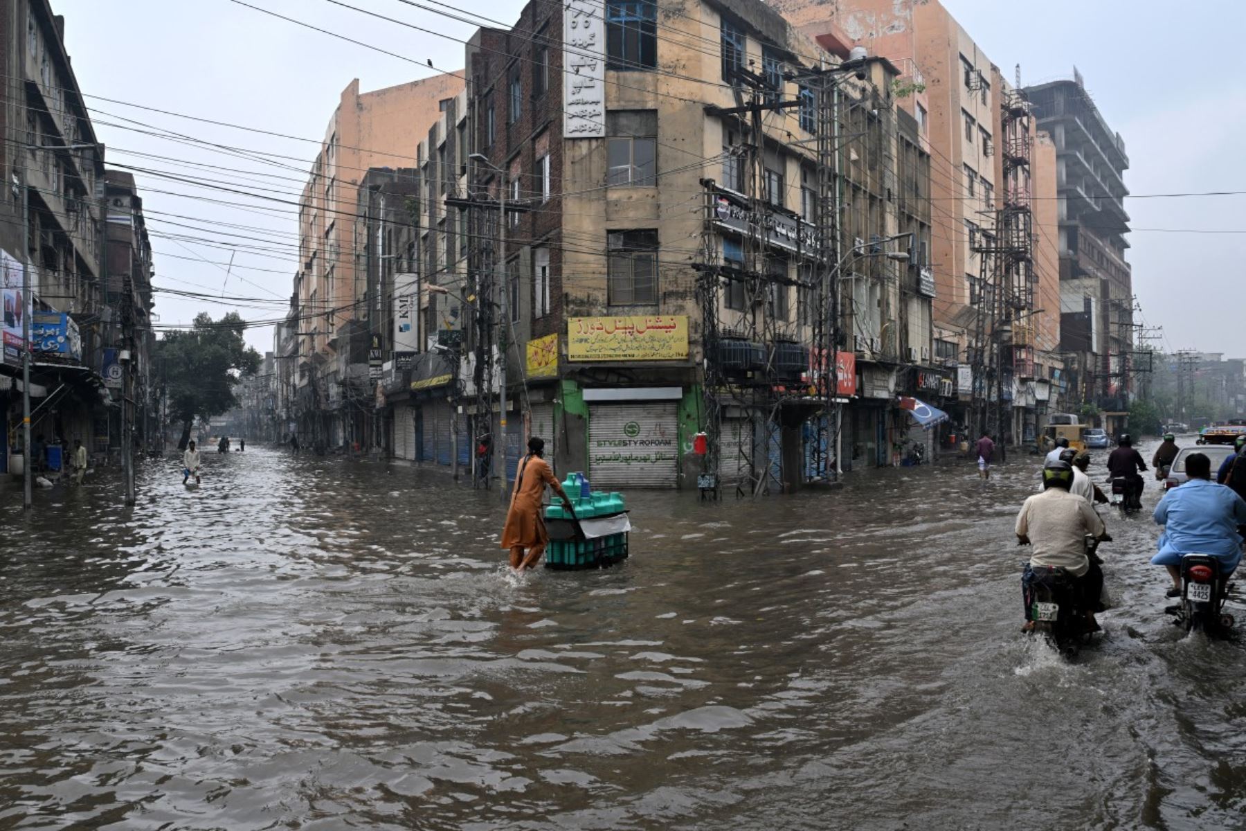 Las personas se desplazan por una calle inundada tras las fuertes lluvias en Lahore, Pakistán, el 25 de julio de 2026. Foto: AFP