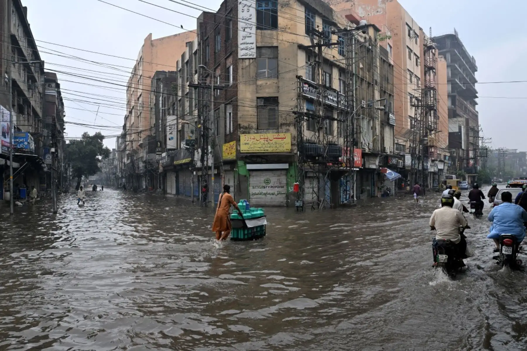 Las personas se desplazan por una calle inundada tras las fuertes lluvias en Lahore, Pakistán, el 25 de julio de 2026. Foto: AFP