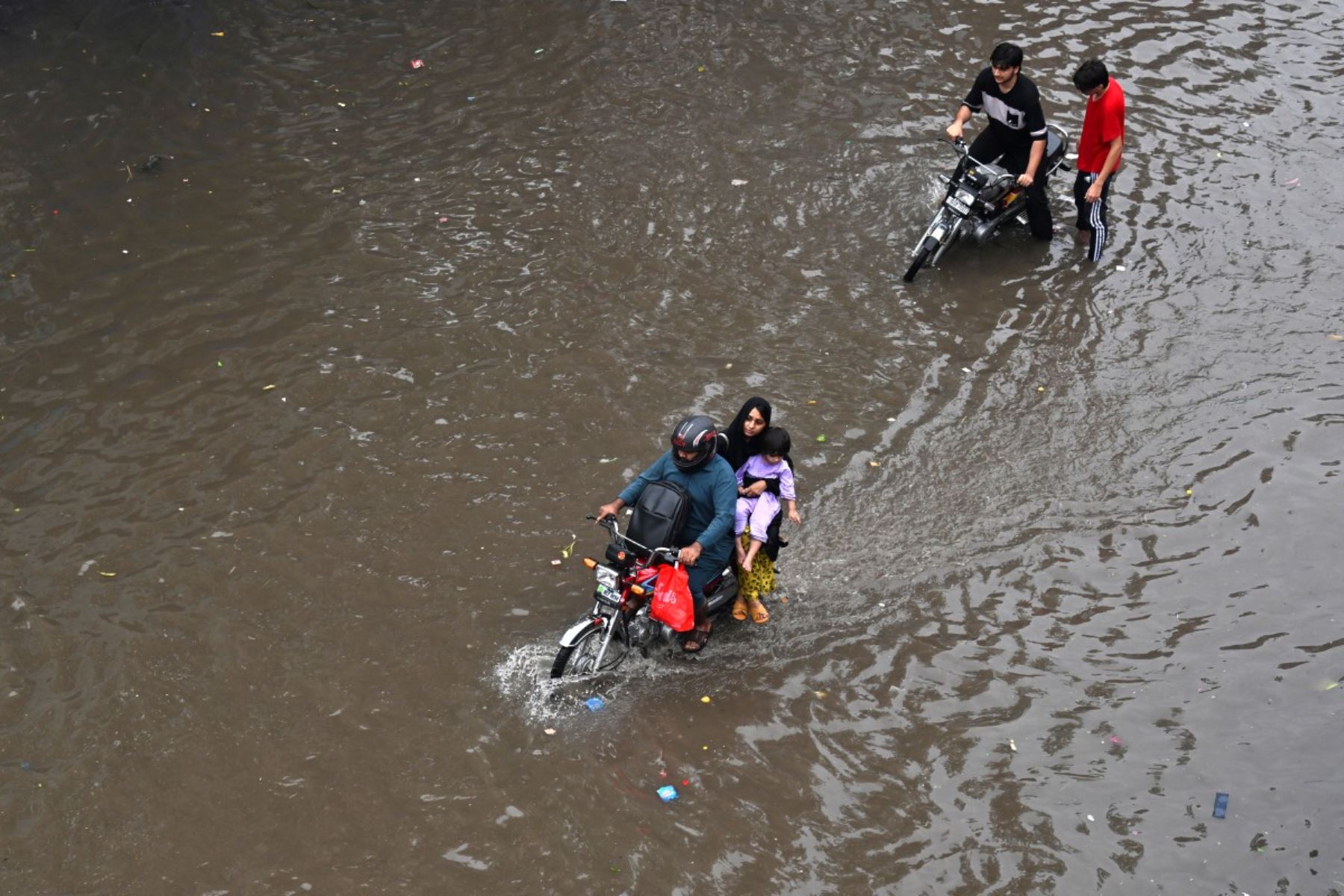 Las personas se desplazan por una calle inundada tras las fuertes lluvias en Lahore, Pakistán, el 25 de julio de 2026. Foto: AFP