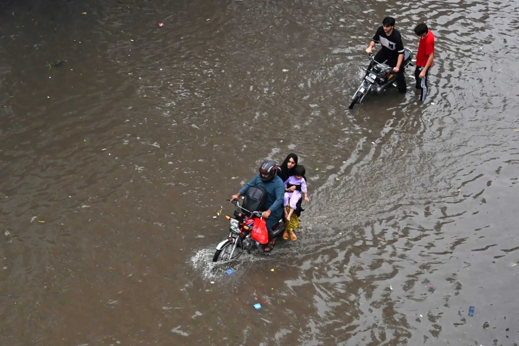 Las personas se desplazan por una calle inundada tras las fuertes lluvias en Lahore, Pakistán, el 25 de julio de 2026. Foto: AFP