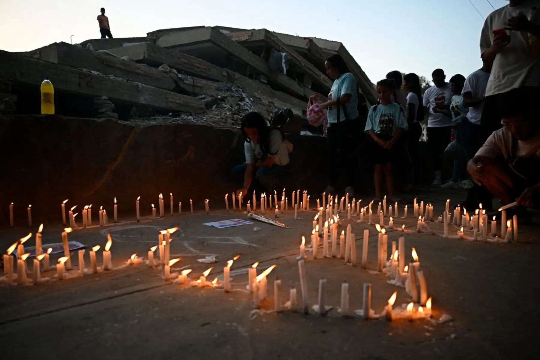 Familiares encienden velas durante una misa por las víctimas en Caraballeda, Venezuela, un mes después del terremoto que azotó la zona. Foto: AFP