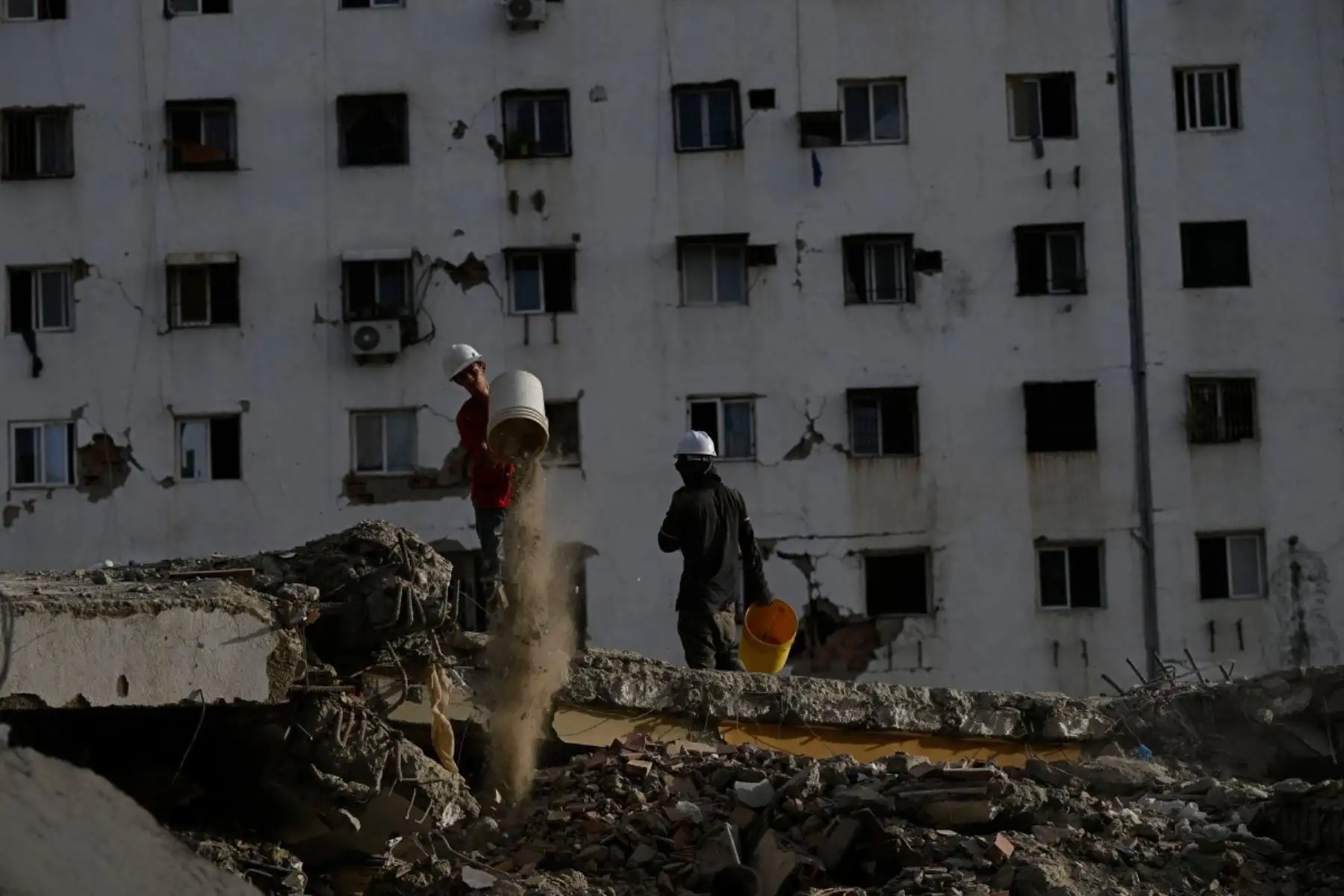 Voluntarios participan en la limpieza de los escombros de un edificio derrumbado en Caraballeda, Venezuela, un mes después del terremoto que azotó la zona. Foto: AFP