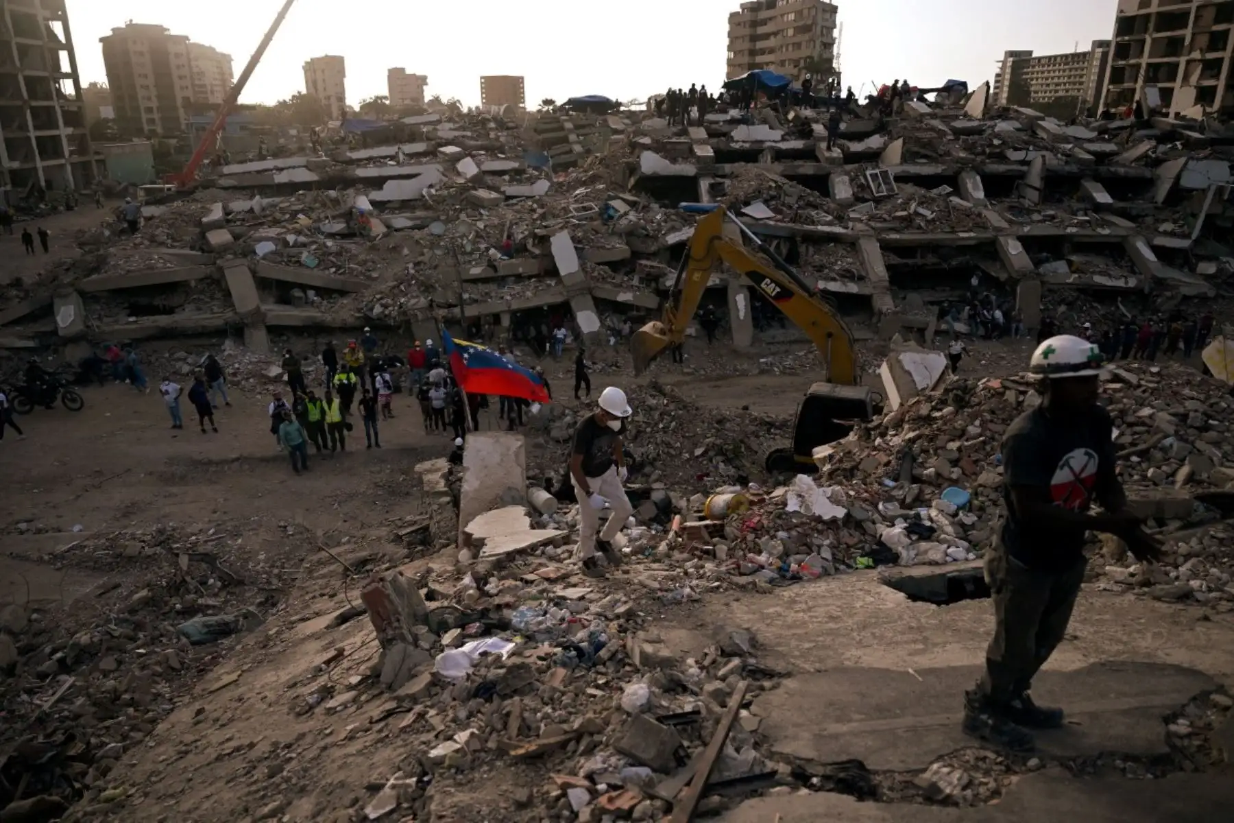 Maquinaria pesada retira los escombros de un edificio derrumbado en Caraballeda, Venezuela, a un mes después de los terremotos del 24 de junio. Foto: AFP