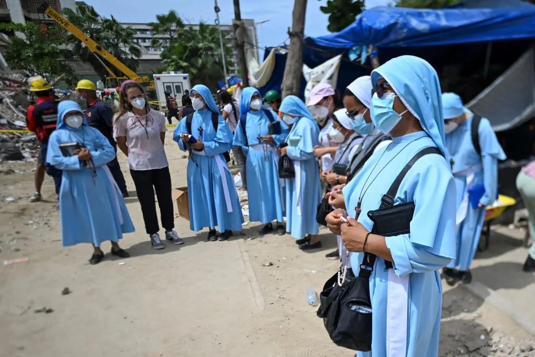 Monjas permanecen cerca de los escombros de un edificio derrumbado en Caraballeda, Venezuela, a un mes después de los terremotos del 24 de junio. Foto: AFP