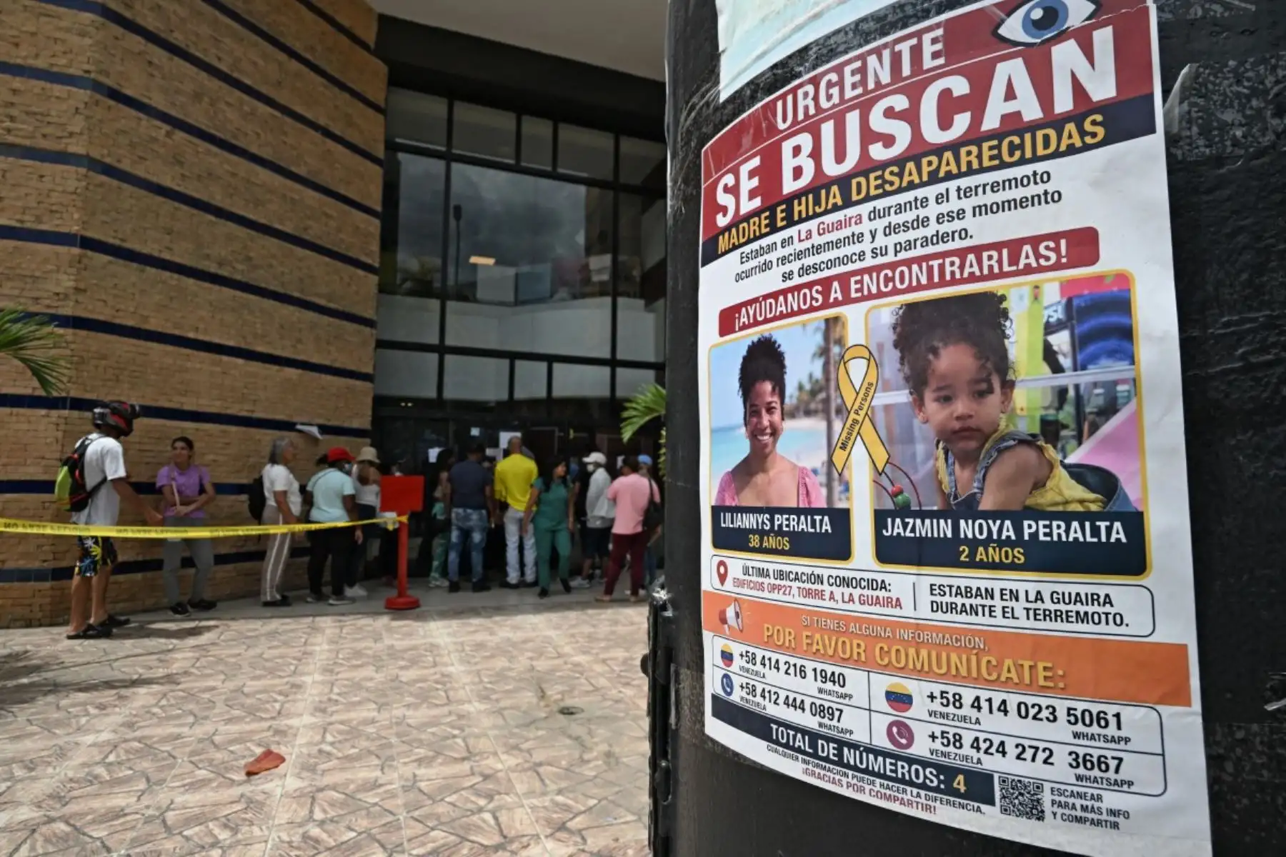 Vista de un cartel con la imagen de personas desaparecidas mientras la gente hace fila afuera de un McDonald