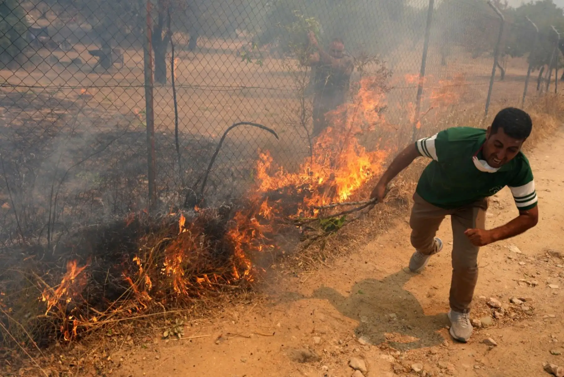Residentes intentan sofocar un el fuego en su propiedad durante un incendio forestal cerca de San Martín de Valdeiglesias, a unos 70 kilómetros al oeste de Madrid, el 26 de julio de 2026. Bomberos españoles combatieron un nuevo frente de incendios cerca de la ciudad costera de Valencia, donde fueron evacuadas al menos 15,000 personas. Foto: AFP