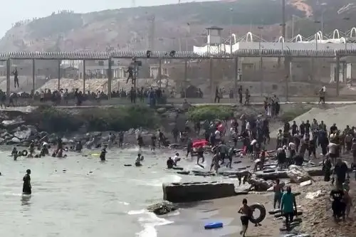 Esta captura de video muestra a migrantes nadando y corriendo para llegar a Ceuta, enclave español en el norte de África. Imagen: AFP