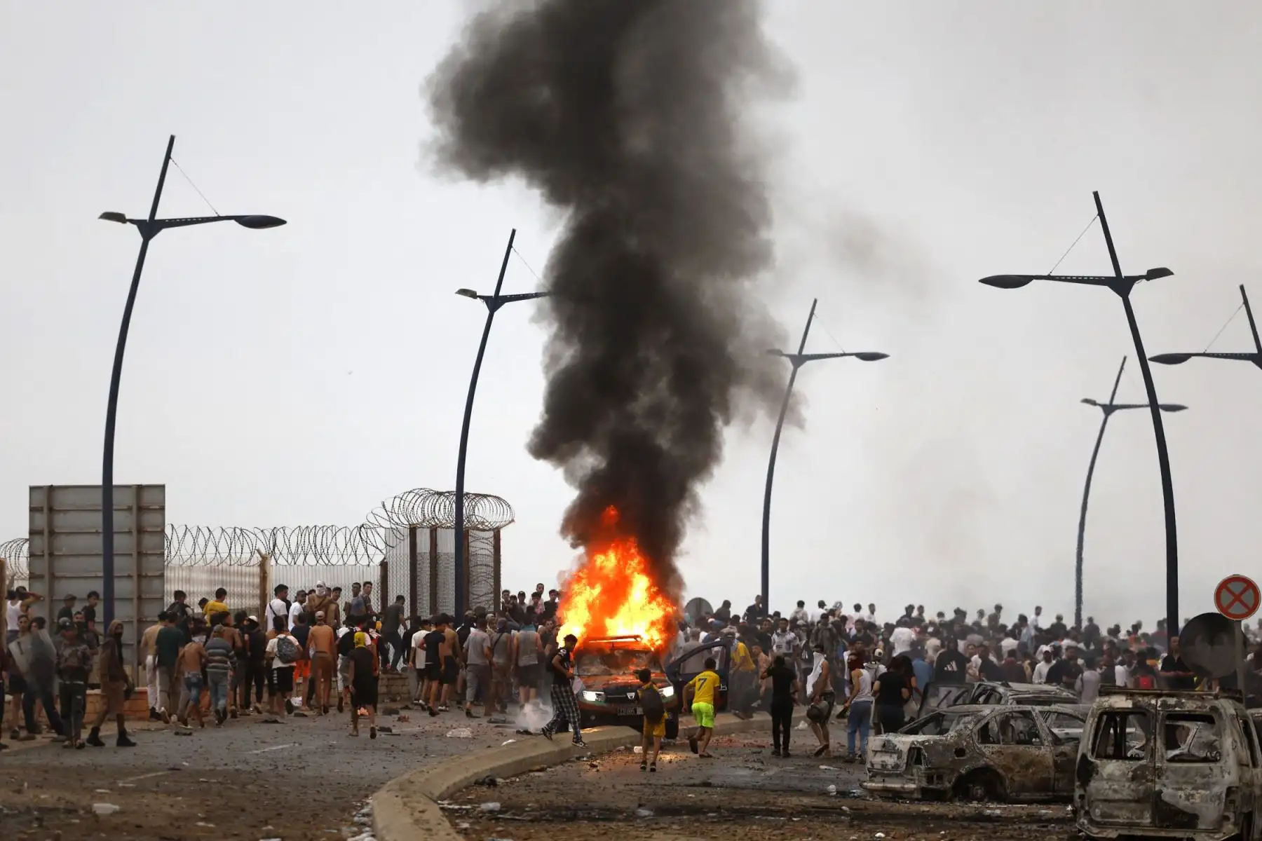 Un vehículo arde en el lugar de los enfrentamientos cerca de Fnideq, en la frontera entre Marruecos y España. Foto: AFP