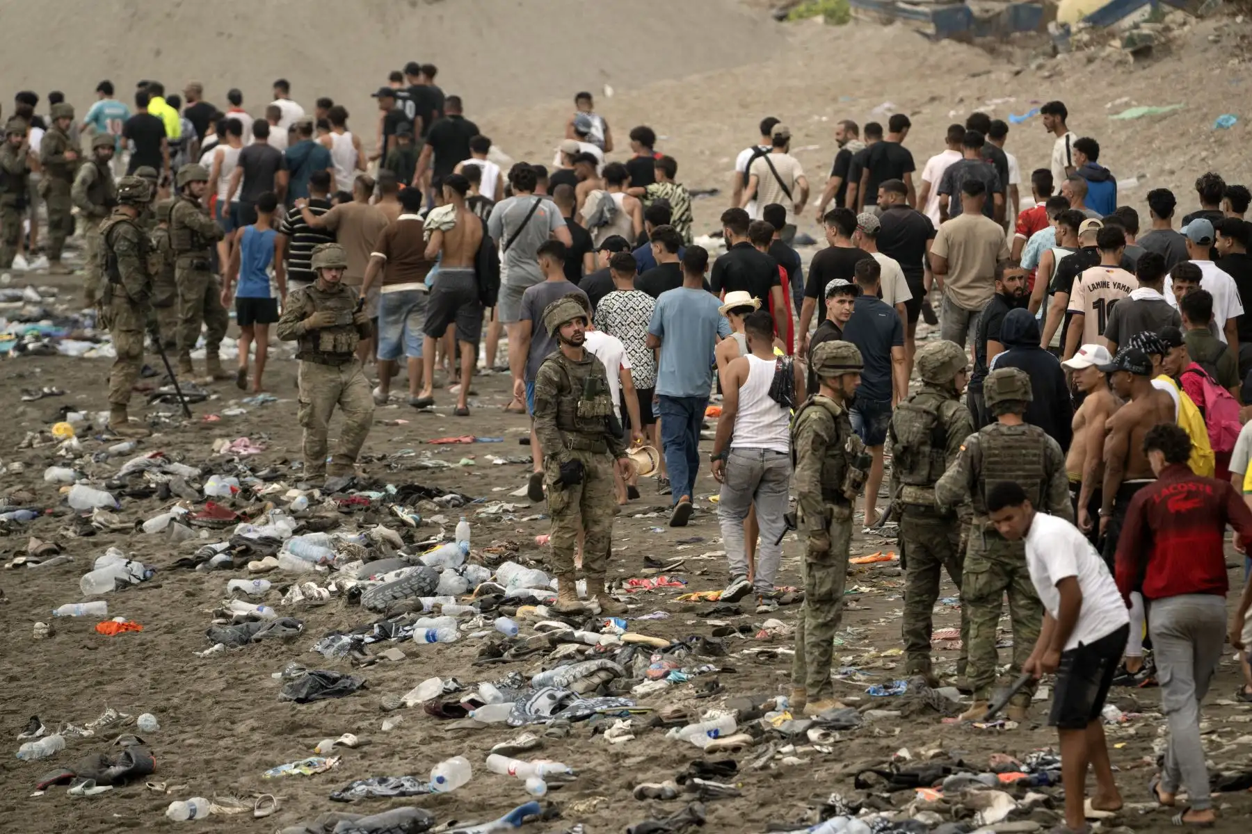 Soldados españoles supervisan el regreso de migrantes a Marruecos tras haber cruzado la frontera hacia el enclave de Ceuta (31 de julio 2026). Foto: AFP