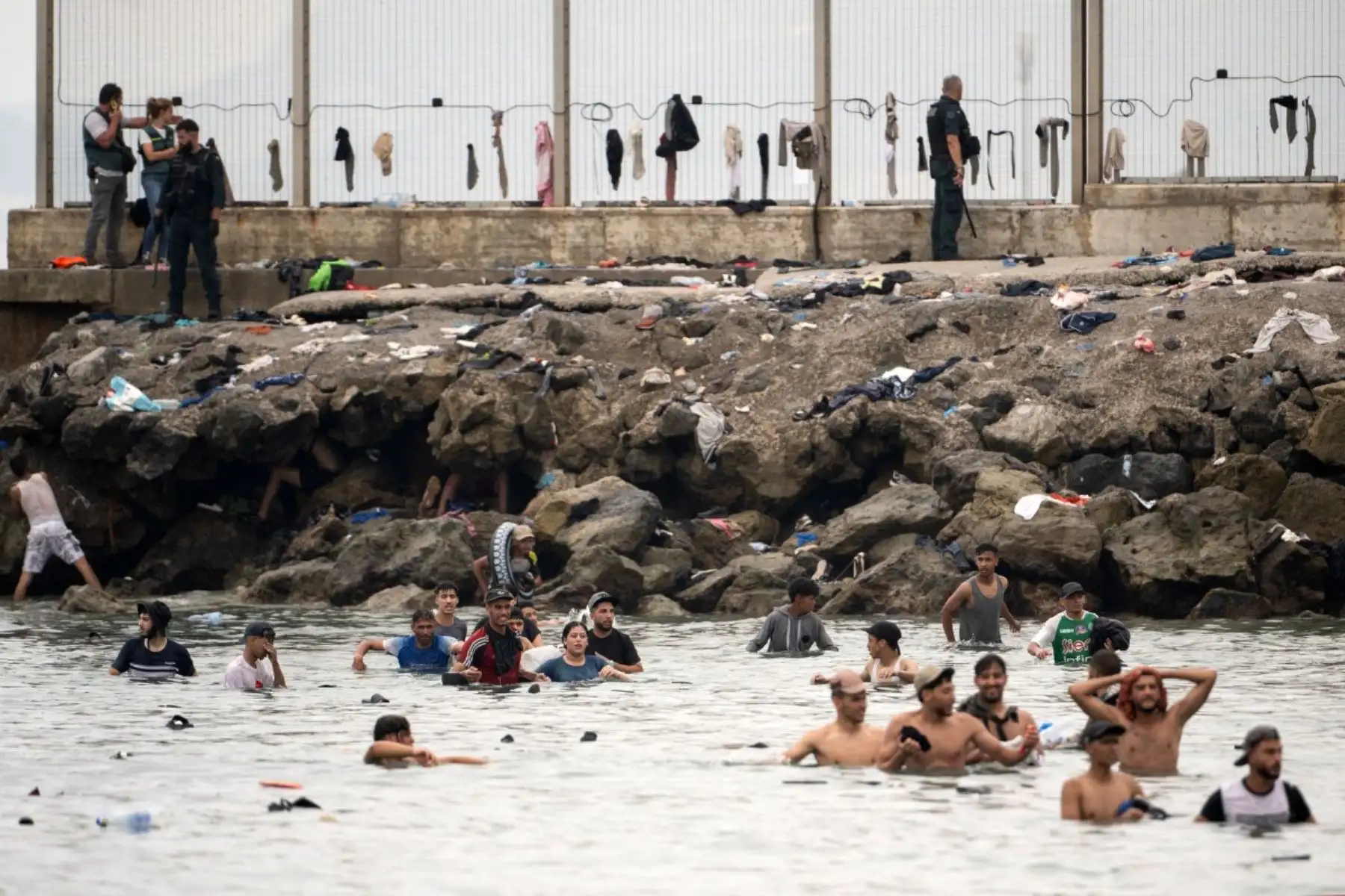 Agentes de la Guardia Civil española controlan a migrantes que intentan cruzar a nado las aguas cercanas a la frontera con Marruecos para entrar en el enclave español de Ceuta, en el norte de África, el 31 de julio de 2026. Foto: AFP