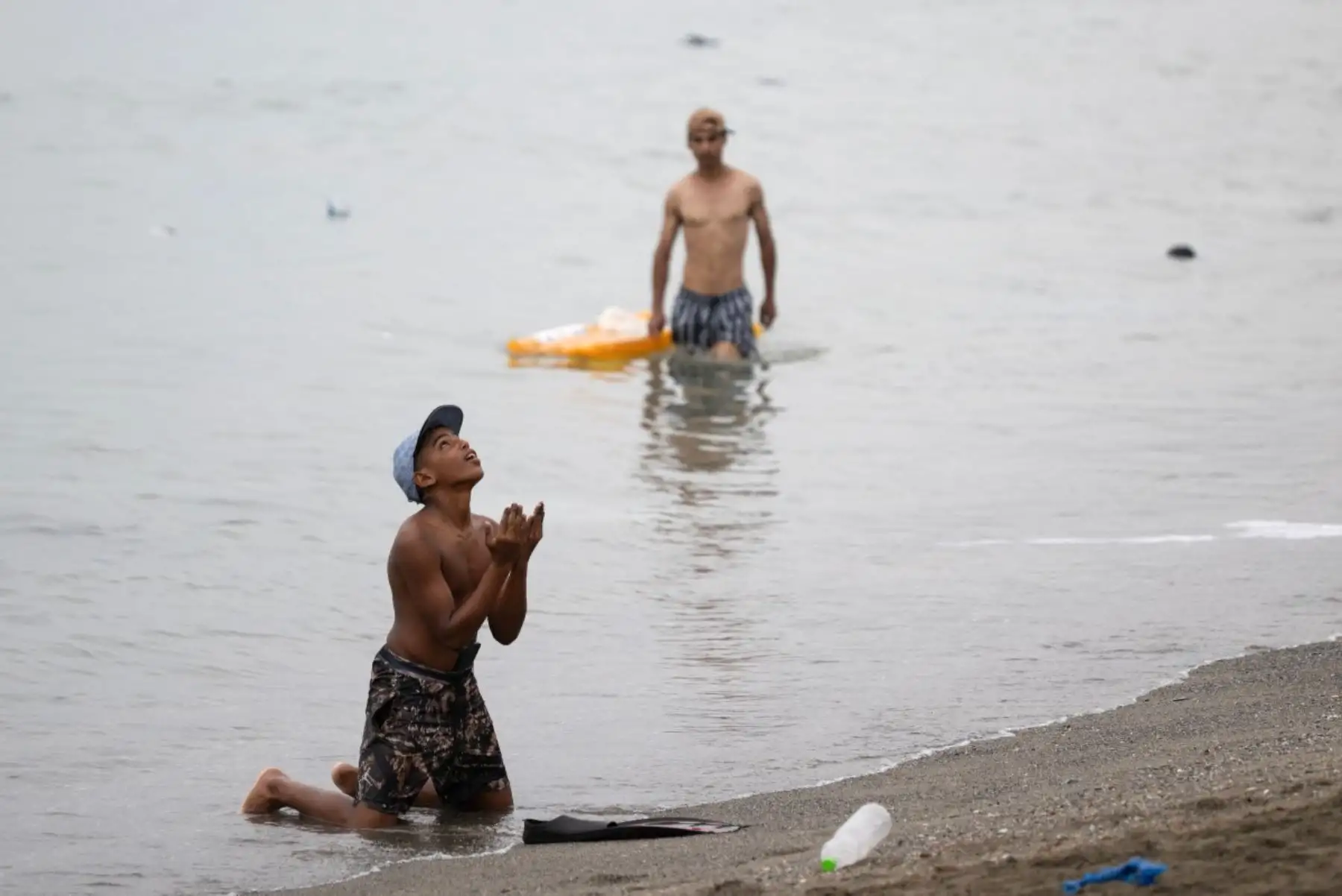 Un migrante hace gestos en la playa, cerca de la barrera fronteriza con Marruecos, para entrar en el enclave español de Ceuta, en el norte de África, el 31 de julio de 2026. Foto: AFP